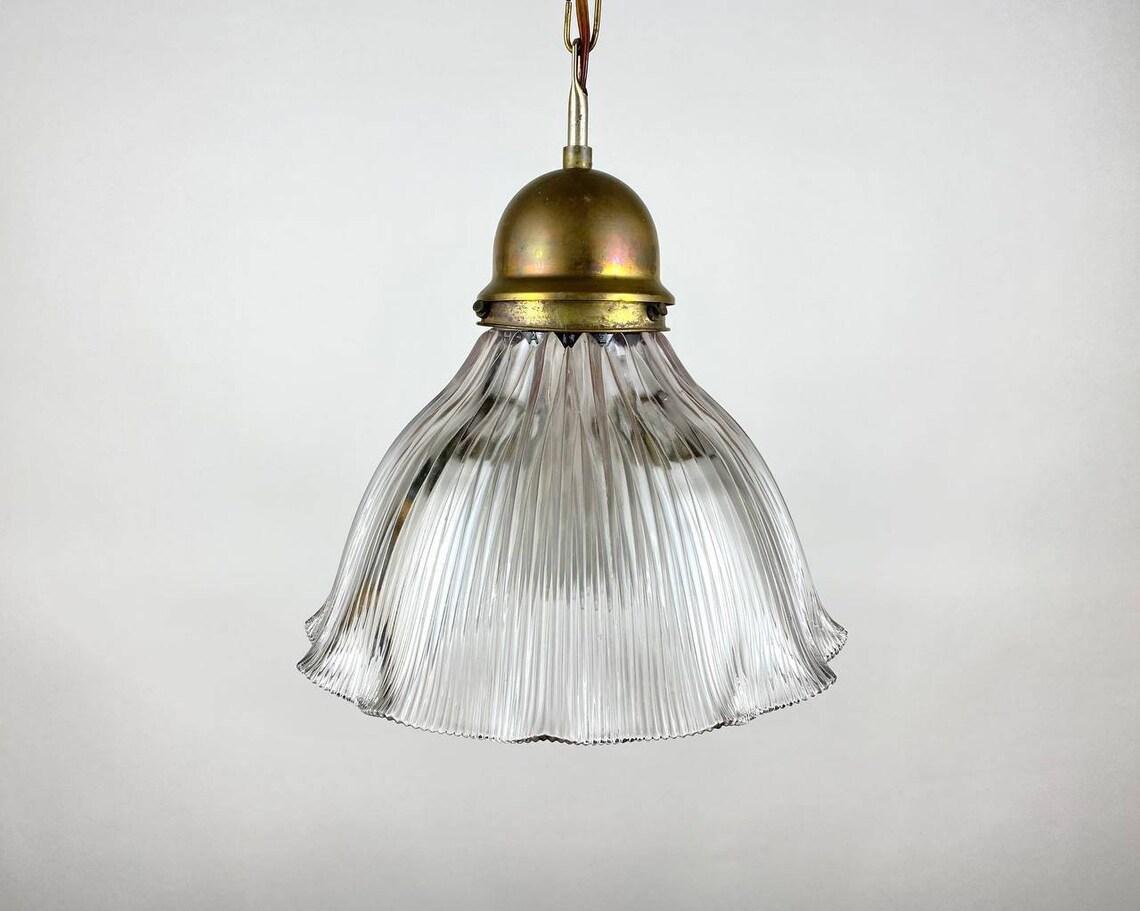 Antique hanging lamp – Holophane style – 1910-1920s.

Art Deco hanging lamp Holophane. Beautiful hanging lamp with prismatic glass flower-shaped shade that gives a nice diffused light. Metal details are made of brass.

This antique ceiling lamp