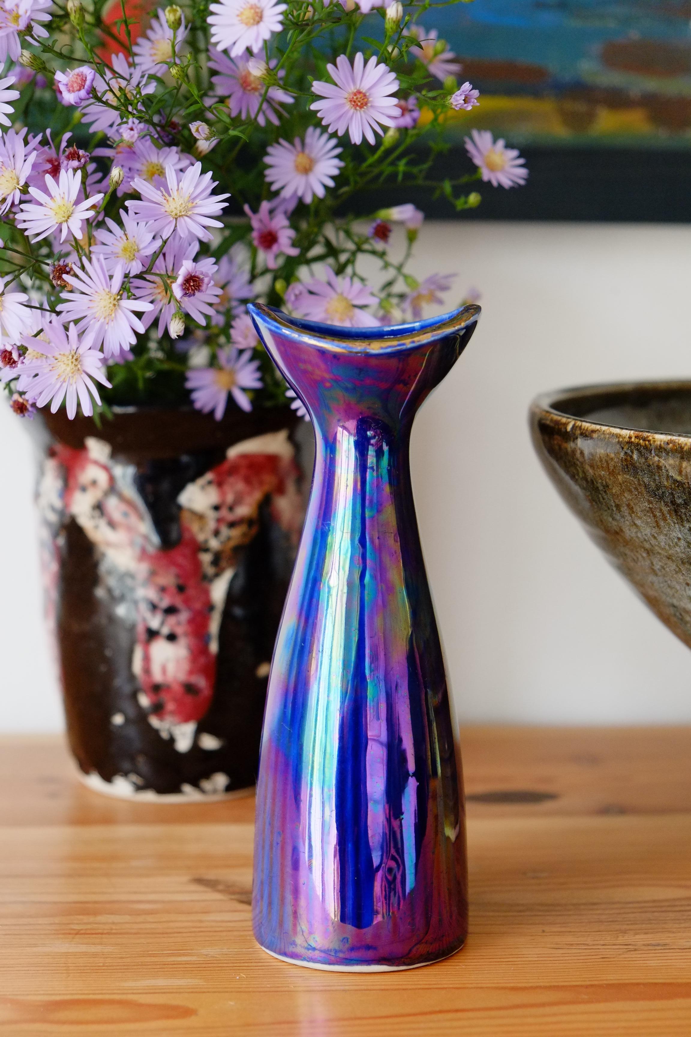 Magnifique vase Art Déco en céramique irisée

Ce vase est recouvert d'une magnifique glaçure irisée en nappe d'huile arc-en-ciel avec une lèvre dorée. Le vase a une petite forme très élégante avec un corps qui se rétrécit et qui s'ouvre sur un col