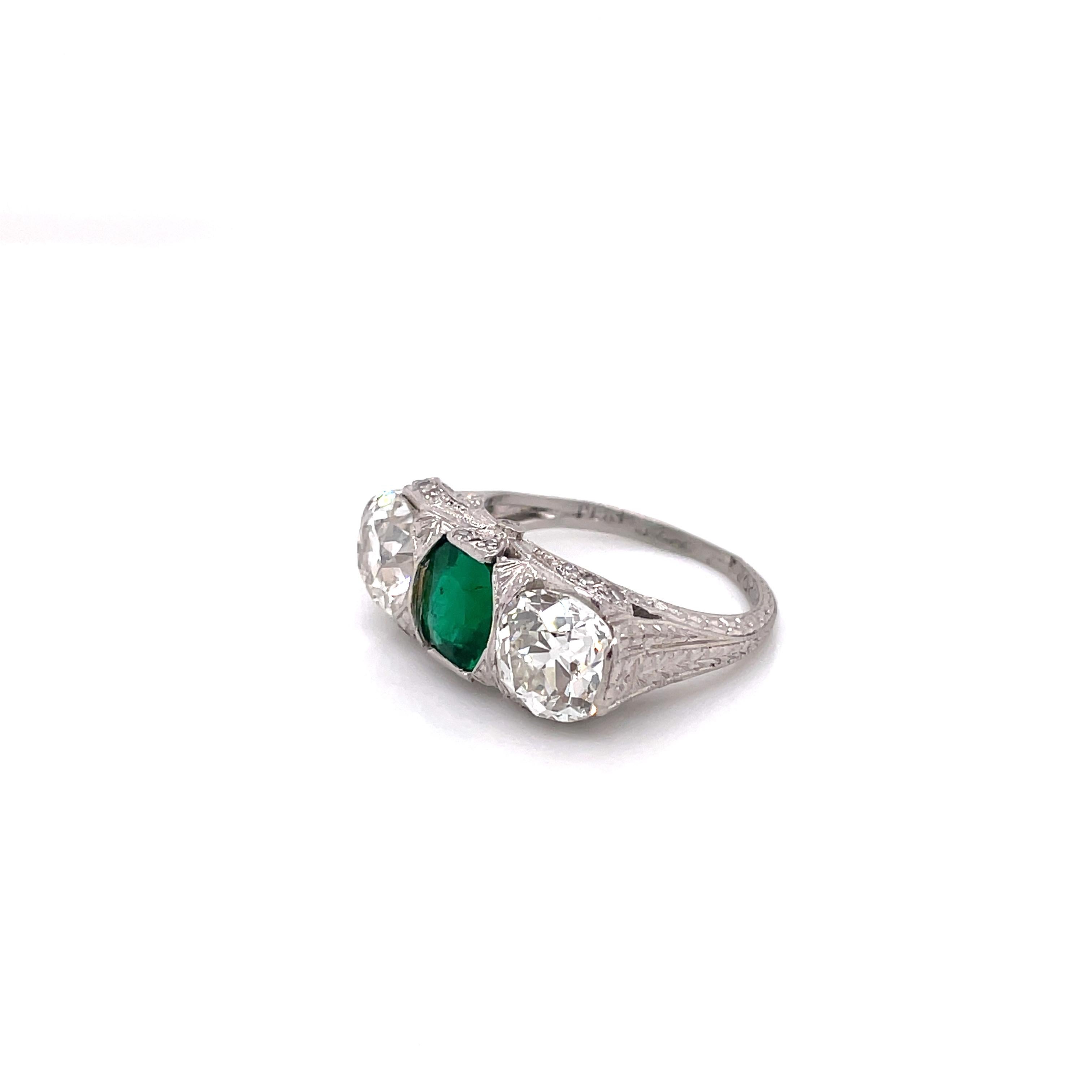 Stunning Art Deco Three-Stone ring with a approximately 1.30CT Emerald as the center stone. There are 2 Old European cut VS1-VS2 diamonds on each side of the emerald. There are 30 Old Mine cut VS diamonds totaling to approximately 0.20CTTW on the