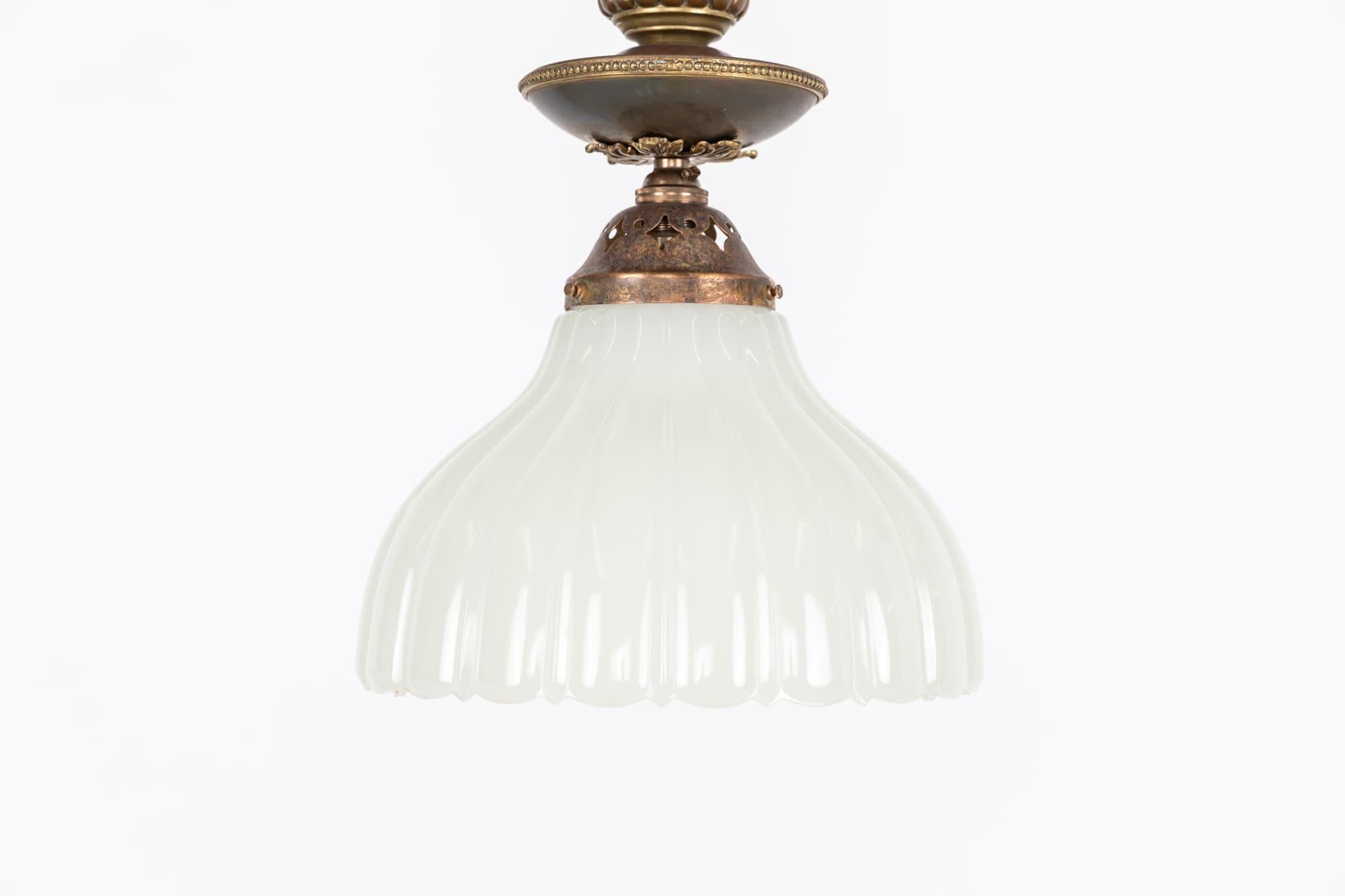 An incredibly elegant moonstone pendant lamp with brass gallery. c.1930

Thick pressed moonstone glass of fluted design with elongated brass gallery.

Rewired with black twisted flex.
