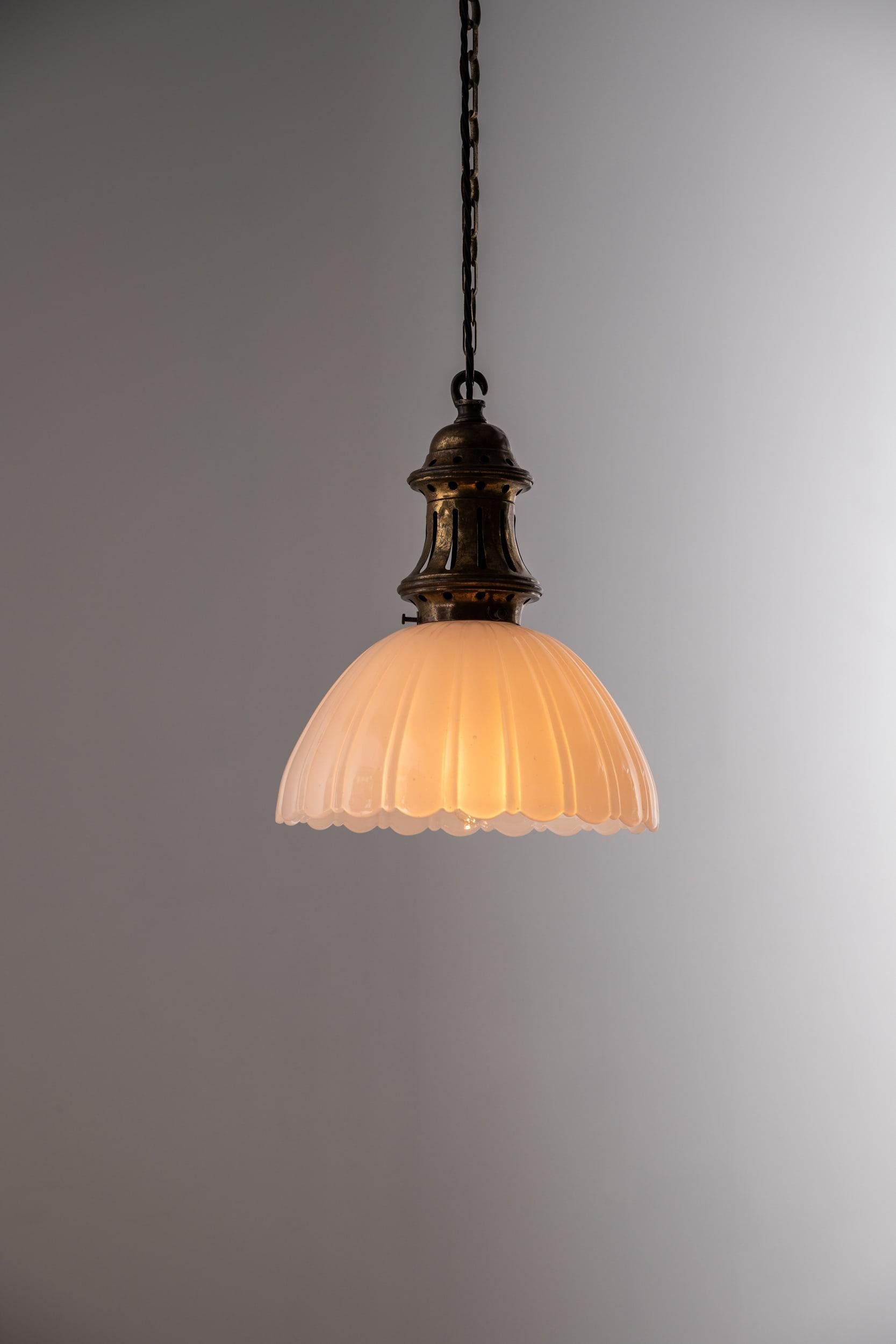 

An incredibly elegant moonstone pendant lamp with brass gallery. c.1930

Thick pressed moonstone glass of fluted design with elongated brass gallery, chain and ceiling hook.

Rewired with 1m of black round flex.

