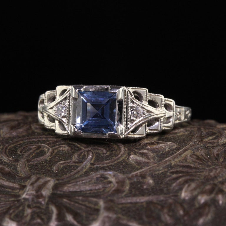 Beautiful Antique Art Deco Lambert Bros 18K White Gold Yogo Sapphire Engagement Ring. This gorgeous ring is crafted in 18k white gold. The ring holds a Yogo Gulch sapphire in the center that is a gorgeous blue and very clean. It has two old european