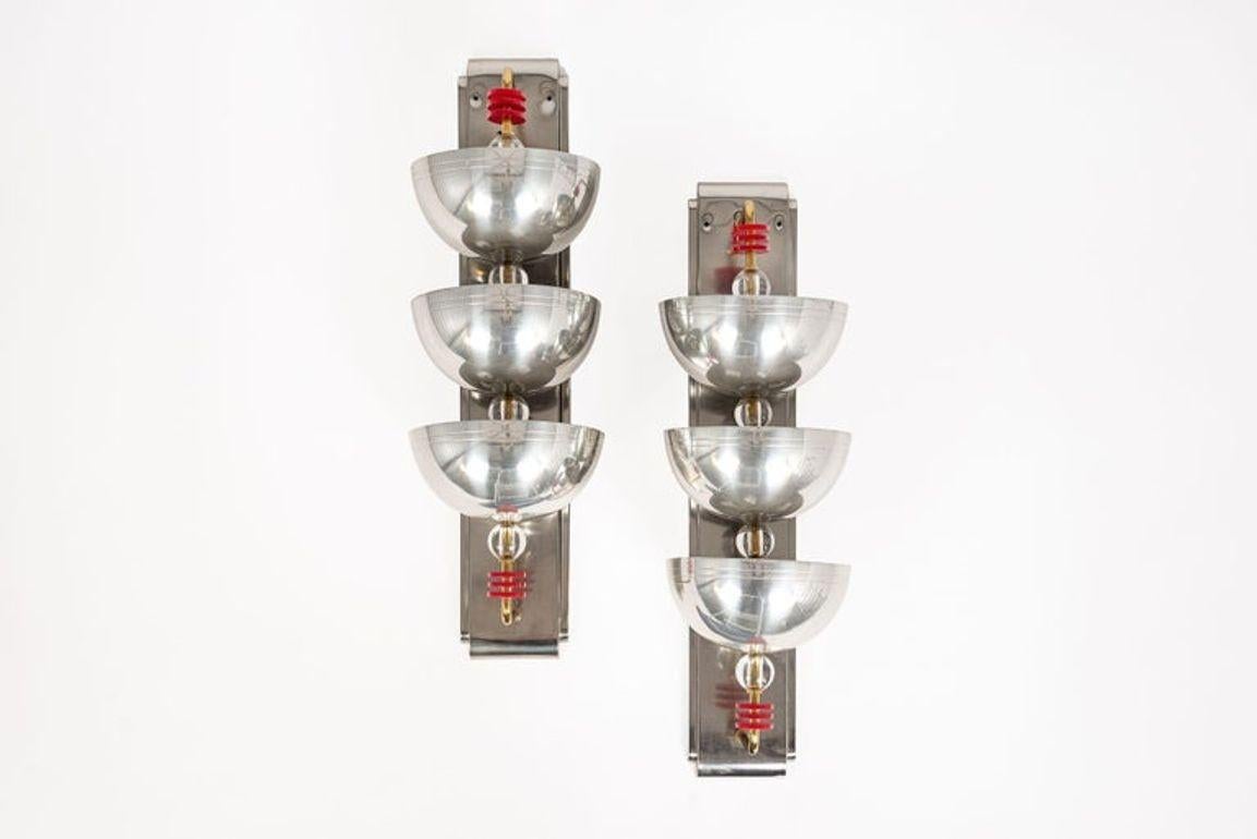 Questa incredibile coppia di antiche applique d'argento Art Déco risale al 1940 circa. Le lampade ad applique sono caratterizzate da tre grandi coppe di metallo su barre di ottone montate su pesanti piastre da parete in metallo massiccio con sfere