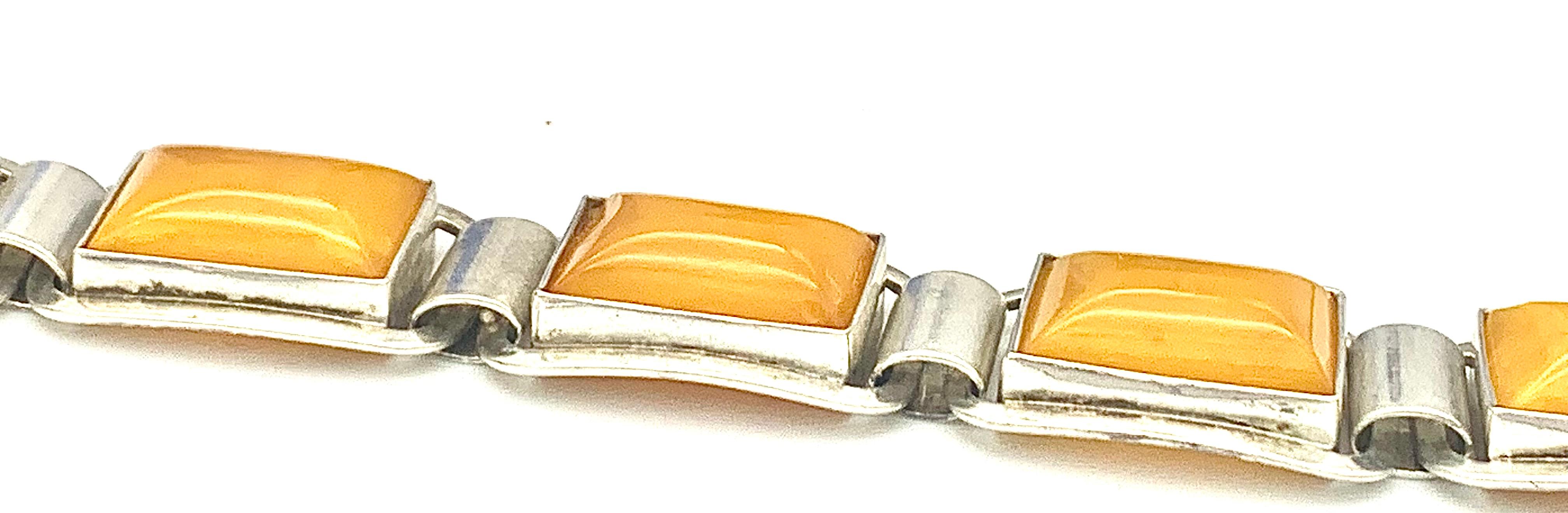 This elegant silver Art Deco Bracelet has been handcrafted and is made up from seven flexible links. Each link is set with a wonderful bight yellow butterscotch amber in sugar loaf cabochon cut. The clasp is marked on the reverse with the word