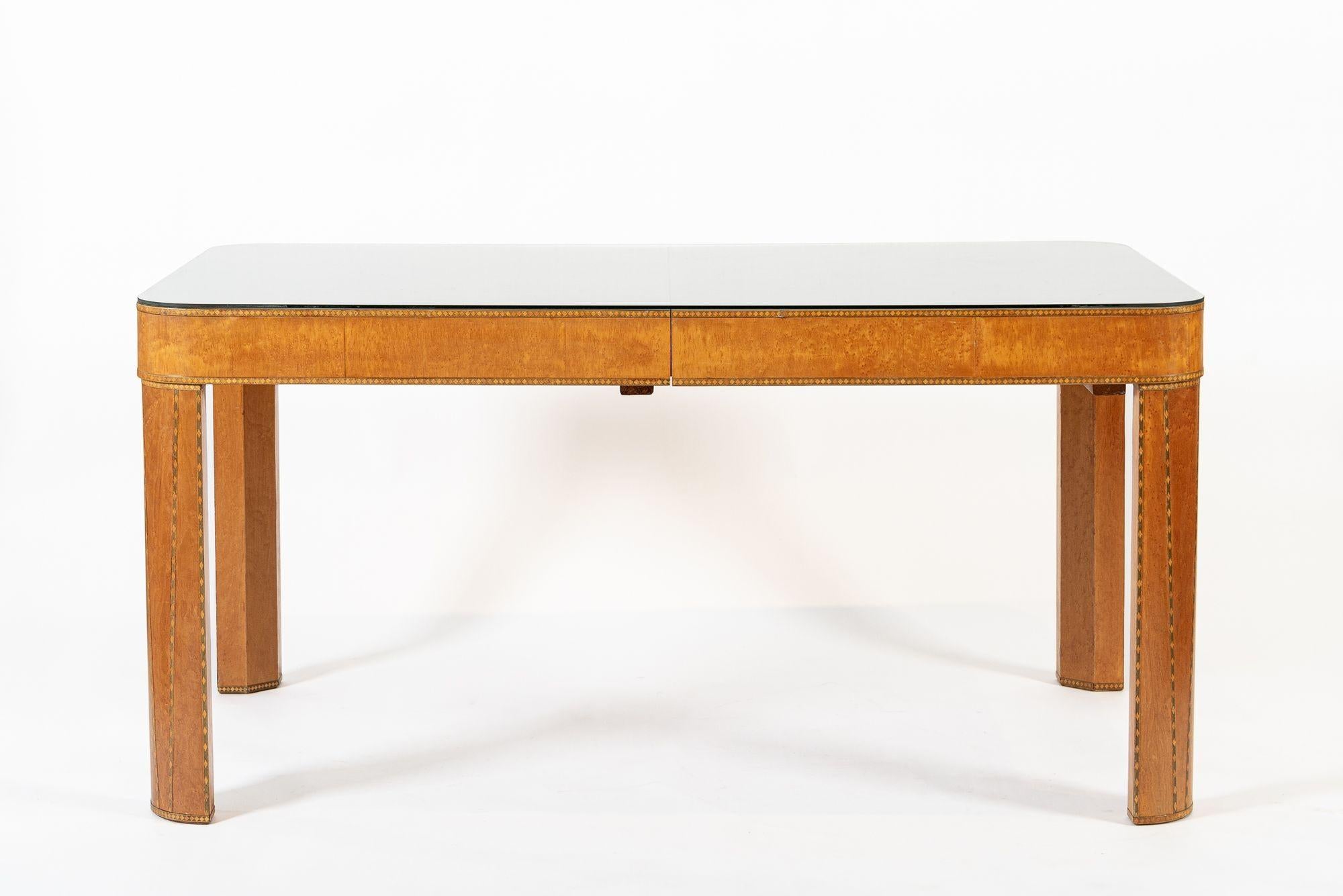 Cette magnifique table de salle à manger antique en bois de style Arte Antiques est datée d'environ 1940. La table est exceptionnellement bien fabriquée en bois massif, en placage d'érable piqué et en placage d'ébène de Macassar avec un motif de