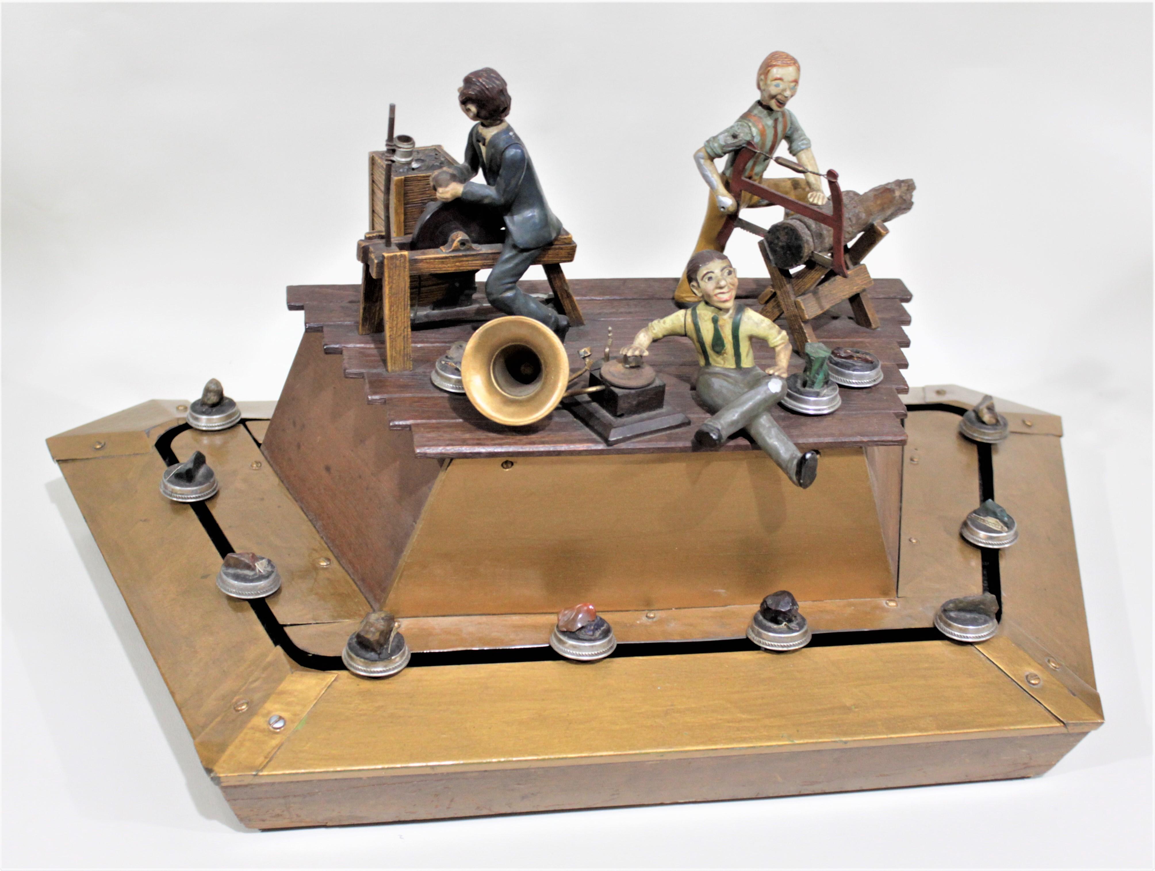 This antique mechanical jewelry store display is presumed to date to the 1920s and to originate from the United States. The display features three animated male figures doing various tasks associated with the craftsmanship of the jewelry store of