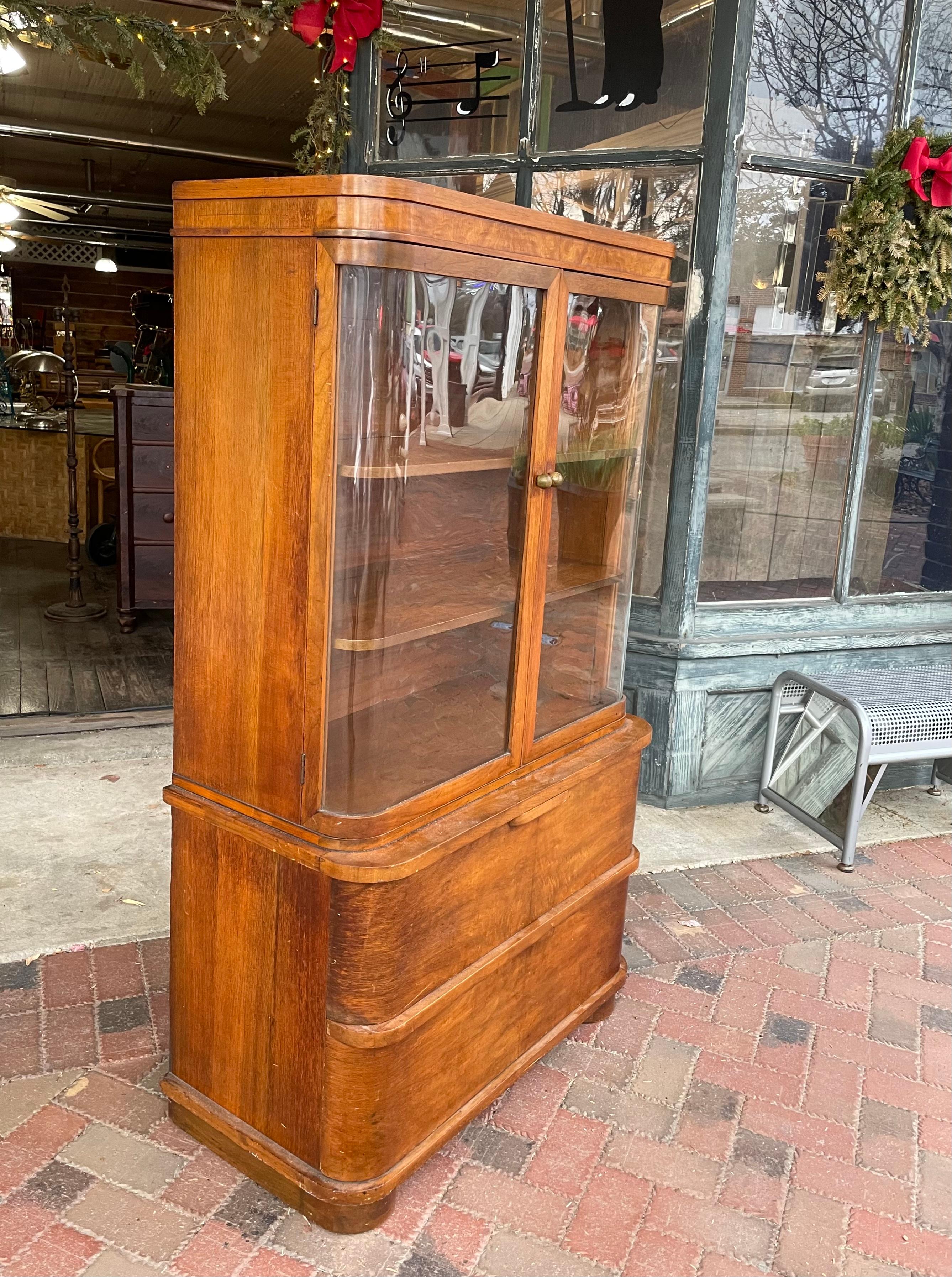 A genuine Art Deco Streamlined Moderne curved glass vitrine with matching rounded architectural features. This is a display cabinet in solid and veneered walnut with classic Art Moderne architecture. Features include a pair of large, deep lower