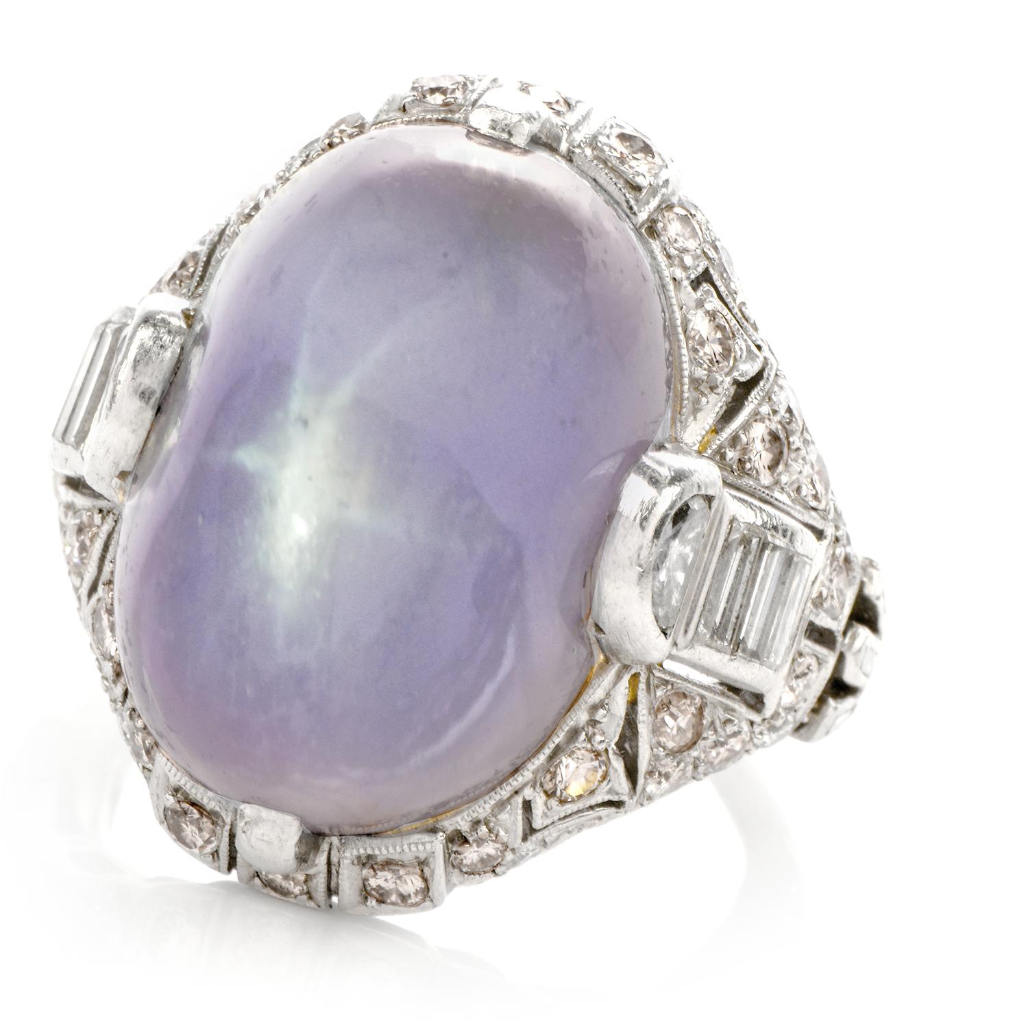 This stunning antique natural art deco lavender genuine star sapphire and diamond ring is crafted in solid platinum, weighing 14 grams and measuring 21mm x 12mm high. Exposing a one prominent prong-set, oval shaped, genuine star sapphire all natural