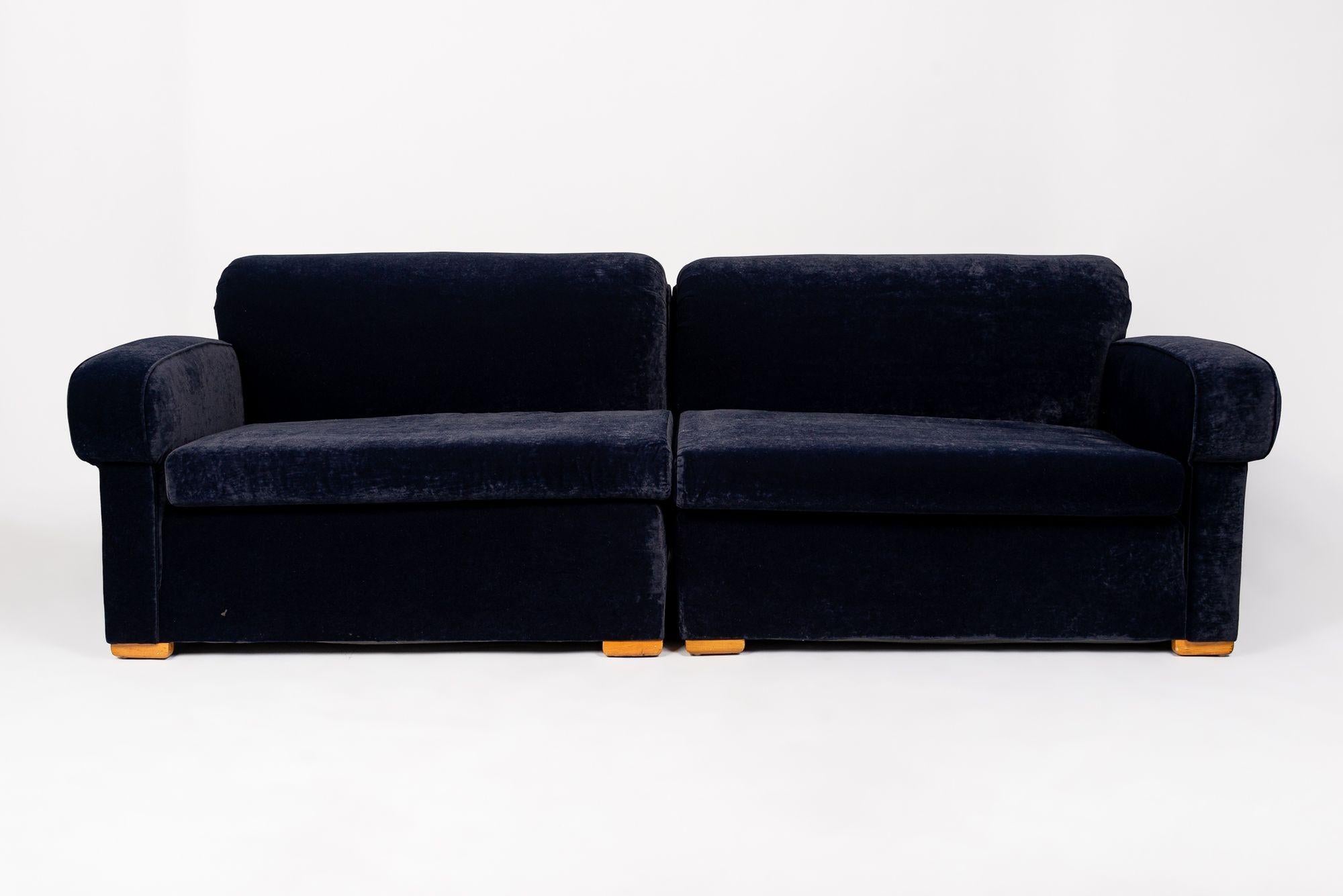 This incredible and rare antique velvet Art Deco sofa is circa 1940. The sofa has a classic Art Deco profile with clean, elegant lines and gentle, streamlined curves. It is incredibly well-built and upholstered in a gorgeous navy blue velvet fabric.