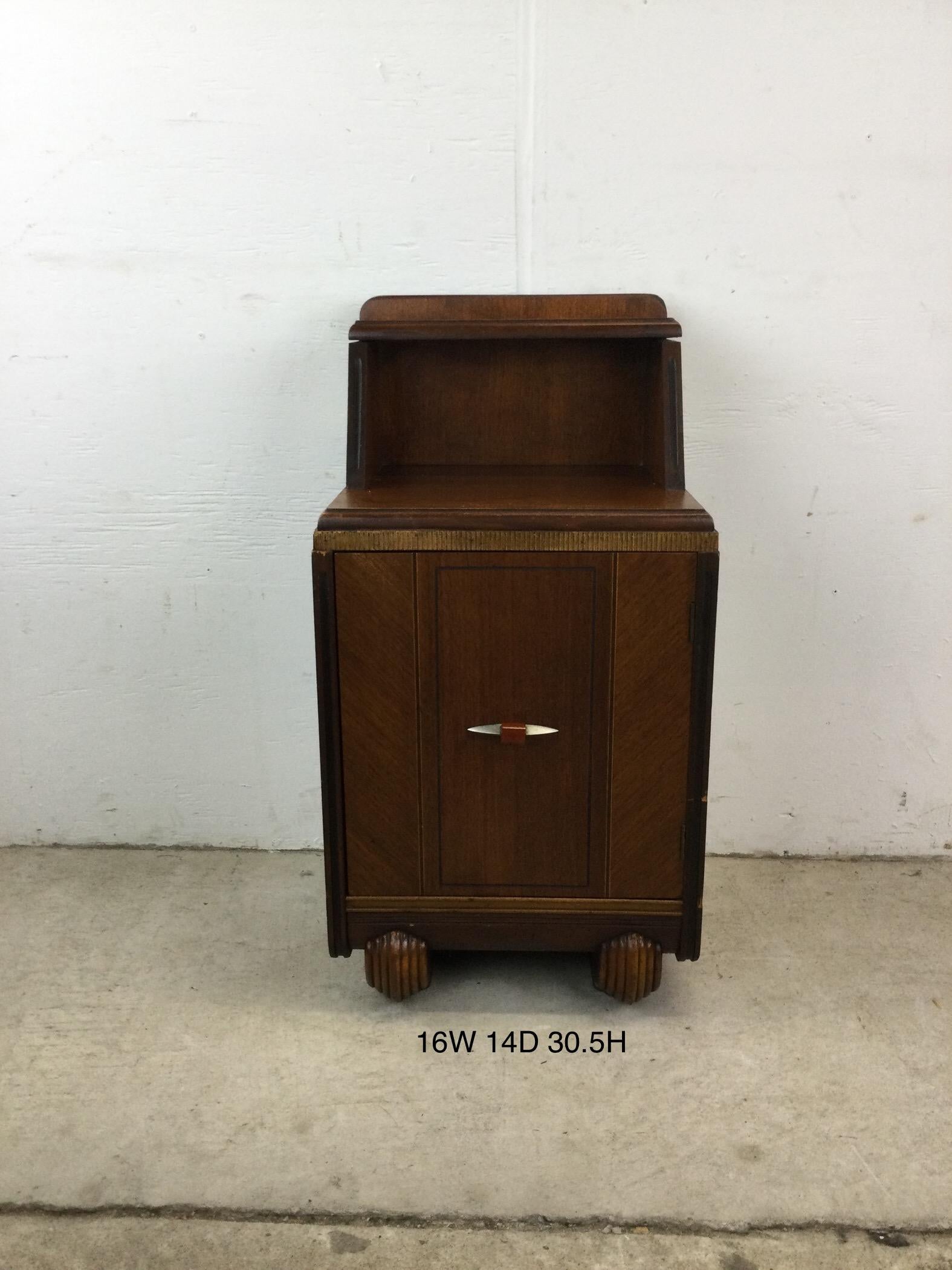 This antique art deco nightstand features hardwood construction, walnut veneer with original finish, single dovetailed we drawer with Bakelite & chrome hardware, cabinet with interior storage, and two unique carved wood feet.   Matching lowboy