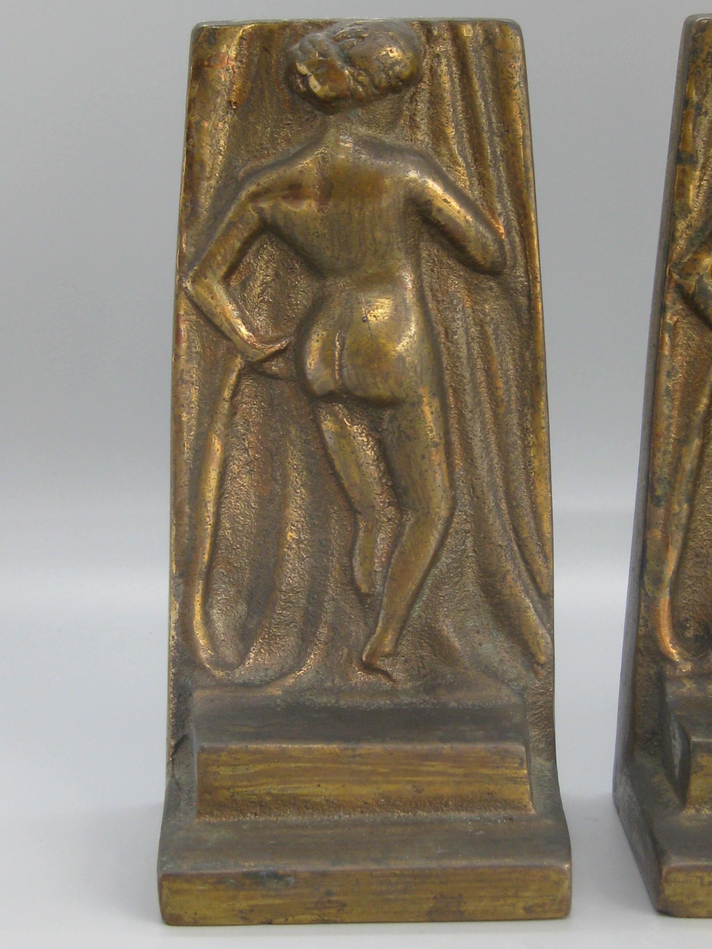 Superbe paire de serre-livres Art Déco en laiton coulé, représentant une femme nue et datant des années 1920 ou du début des années 1930. Ils sont fabriqués en laiton coulé et ont une belle patine foncée. Peut être polie si désiré. Pas de marque de