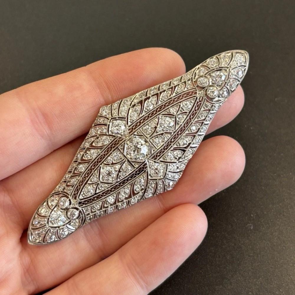 Eine atemberaubende, originelle Art-Déco-Brosche, meisterhaft gefertigt aus Platin mit einer Brosche aus 14 Karat Weißgold. Das Stück befindet sich in einem neuwertigen Zustand, alle Originaldiamanten sind intakt - keine wurden entfernt oder