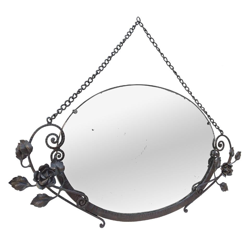 Antique French wall mirror, oval wrought iron frame, Art Deco period, circa 1931. Decor of roses , stylized leaves, patinated by time. Original metal hanging chain. Antique original glass mirror. Antique wood back.