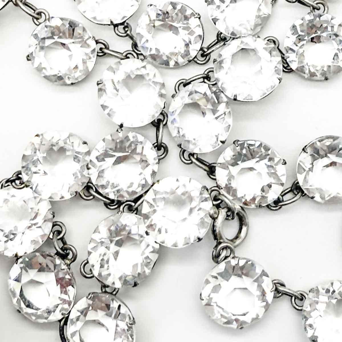 Un'antica collana di Paste Riviere del periodo Art Deco. Più grandi rispetto alla maggior parte di questo stile, le pietre di cristallo di grande peso adornano il collo per un fascino senza tempo. Assolutamente da sogno.
Rivière si riferisce a un