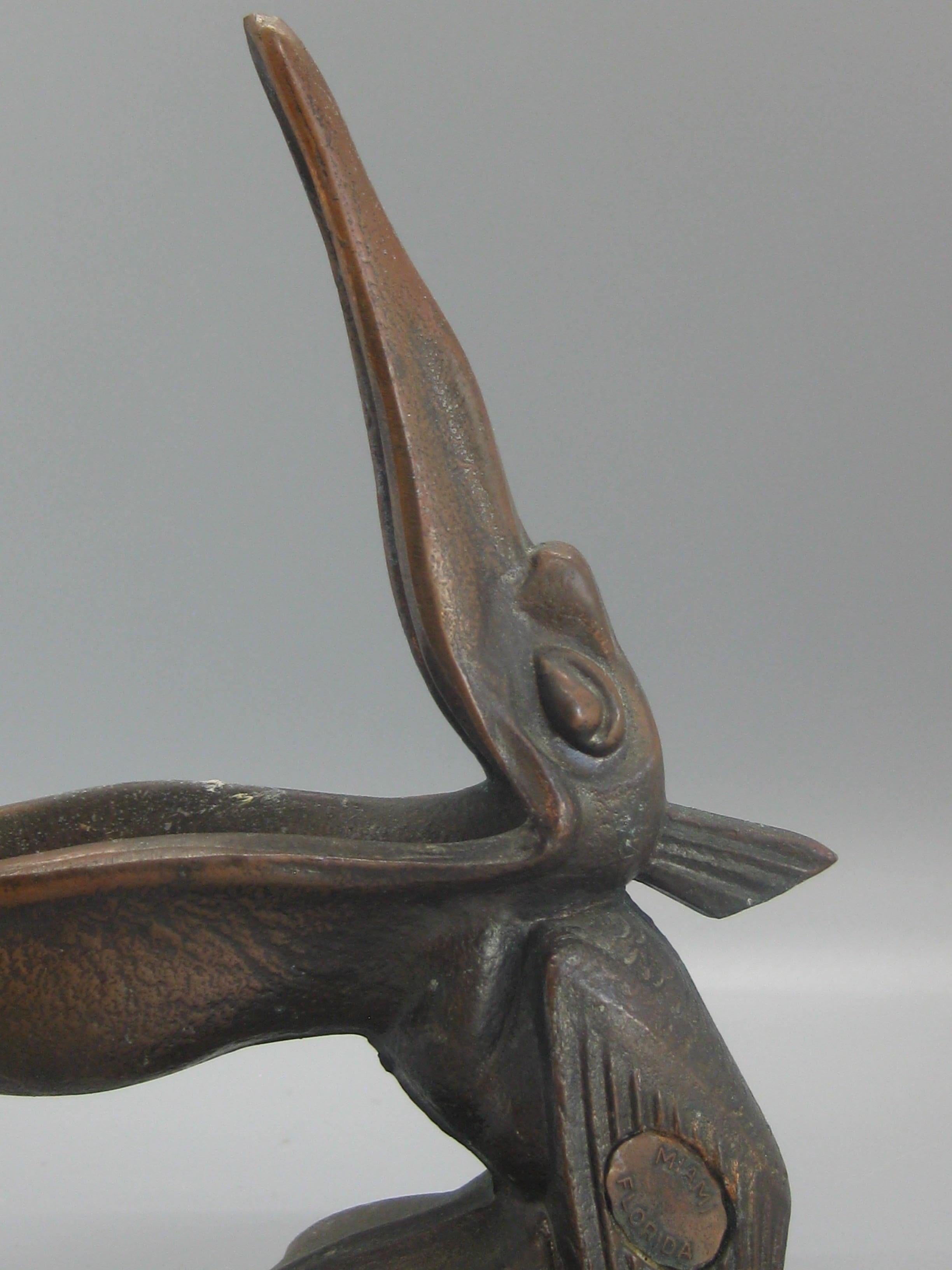 Beautiful antique Art Deco spelter metal with a bronze finish pelican bird figural cigar ashtray dating from the 1930s. The ashtray was a souvenir from Miami, Florida and is marked on the side. No maker marks but might be made by Jennings Bros. or
