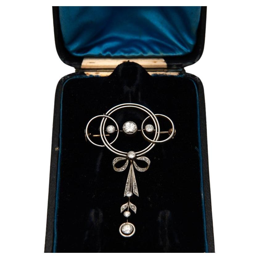 Original antique Art Deco pendant-brooch studded with diamonds.

Fine geometric design of the brooch - three intertwined circles with a centrally embedded old-cut diamond weighing approximately 0.65ct with an additional hanging element topped with a