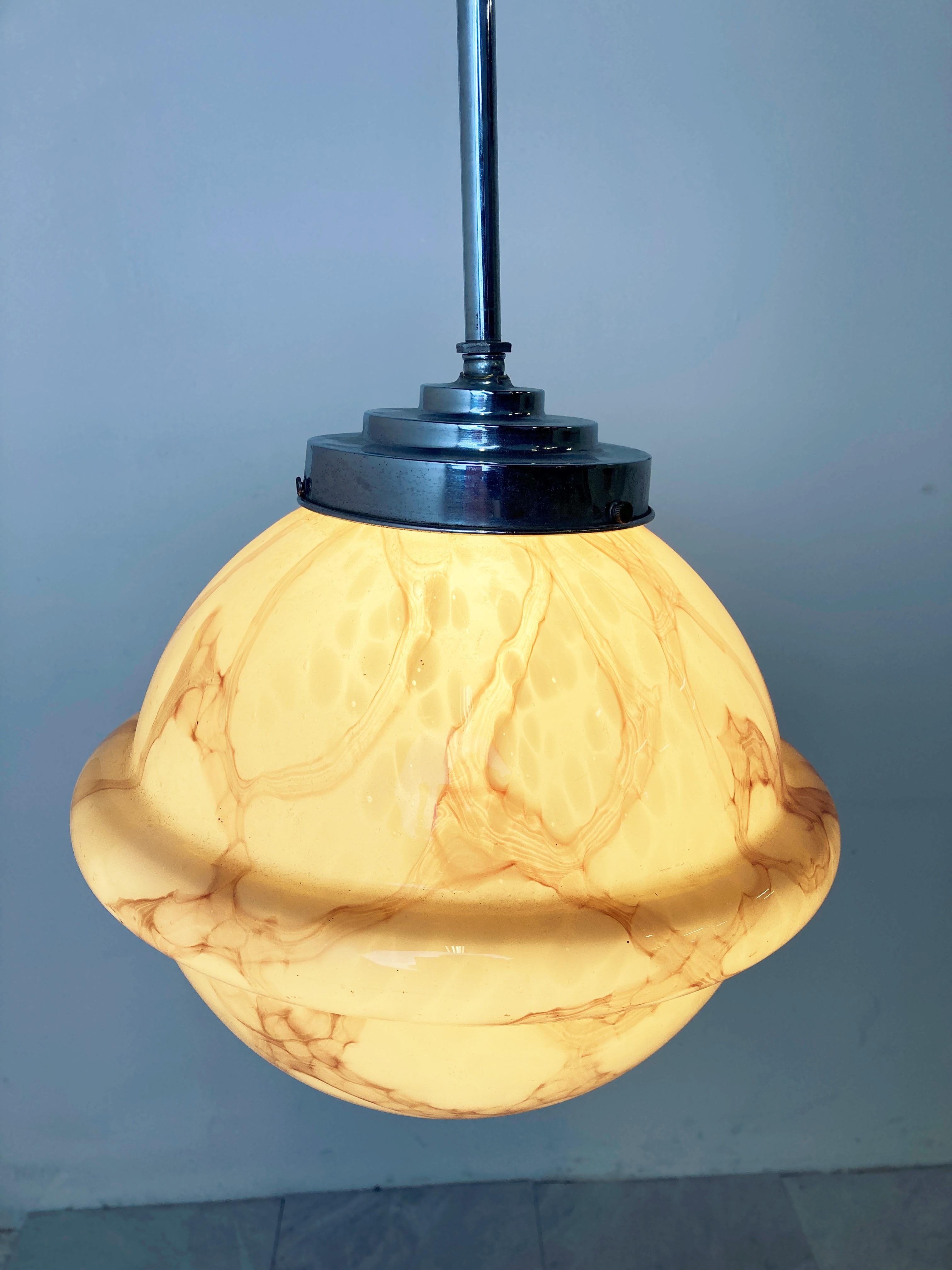 Antike Art-Déco-Hängeleuchte mit einem schönen marmorierten Opal-Lampenschirm, der ein wunderschönes Licht abgibt.

Diese Lampe ist sehr typisch für die Art-Deco-Ära und wurde häufig in Fluren, Büros oder größeren öffentlichen Räumen
