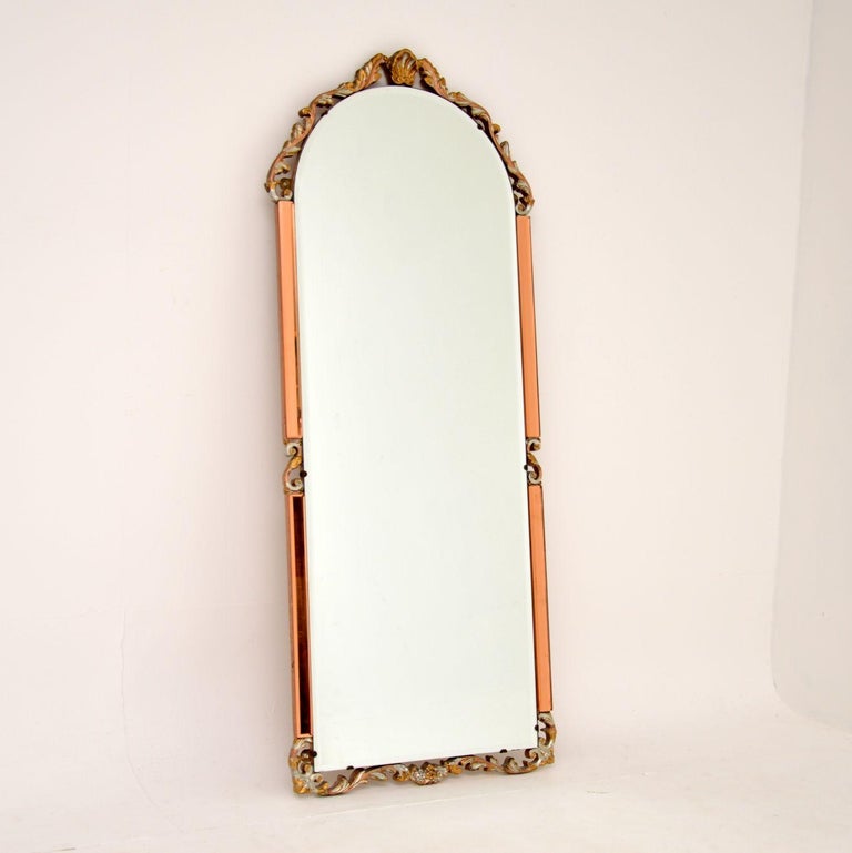 A beautiful and interesting antique mirror made from clear and peach bevelled glass. This was made in England, it dates from around the 1930’s period.

It is from the Art Deco period and is an interesting mix of styles. The peach and clear glass