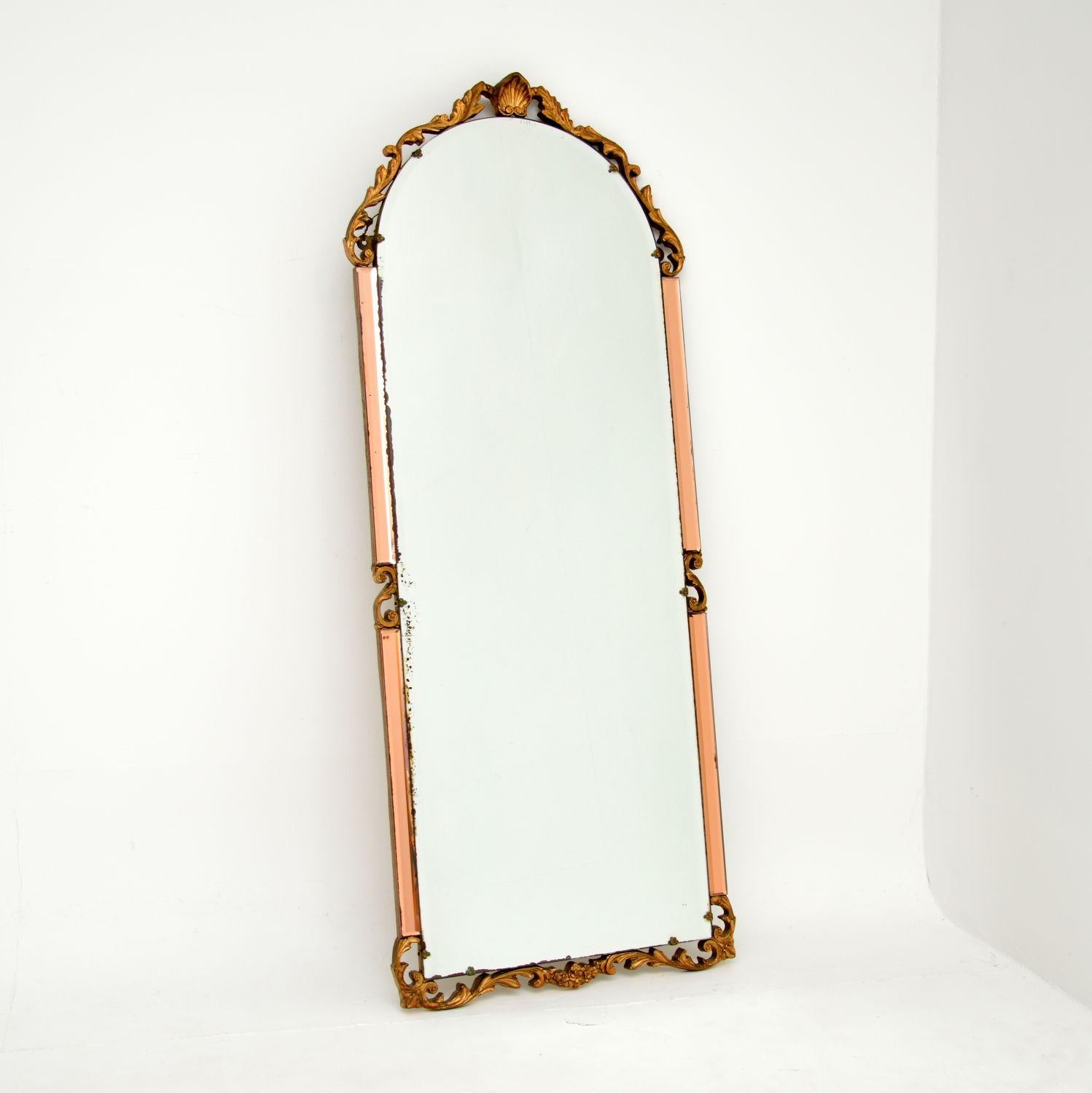A beautiful and interesting antique mirror made from clear and peach bevelled glass. This was made in England, it dates from around the 1930’s period.

It is from the Art Deco period and is an interesting mix of styles. The peach and clear glass