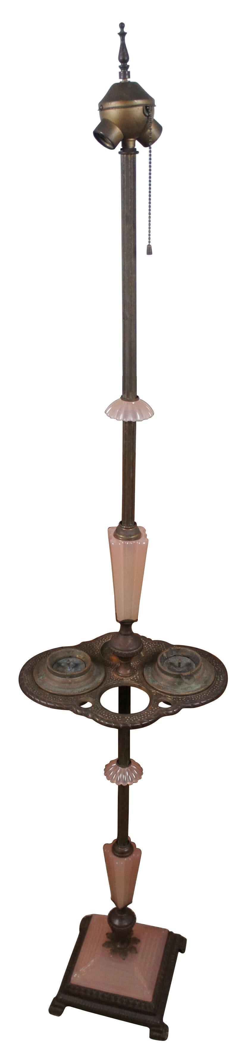 Antique Houze Glass Company pink glass and brass art deco style smoke stand / two light floor lamp; includes two ashtrays and missing the original match holder and lighter.

Measure: 12” x 9.25” x 61.75” / Base - 8.5” x 8.5” (Width x Depth x
