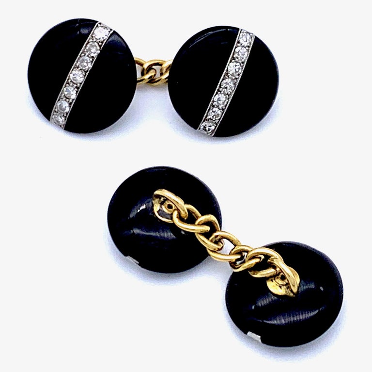 This pair of elegant cufflinks is made of round onyx elements. Each element is decorated with 7 diamonds in platinum millegrain settings.
This particular style is typical for the transition from the the Belle Époque taste to Art Deco.