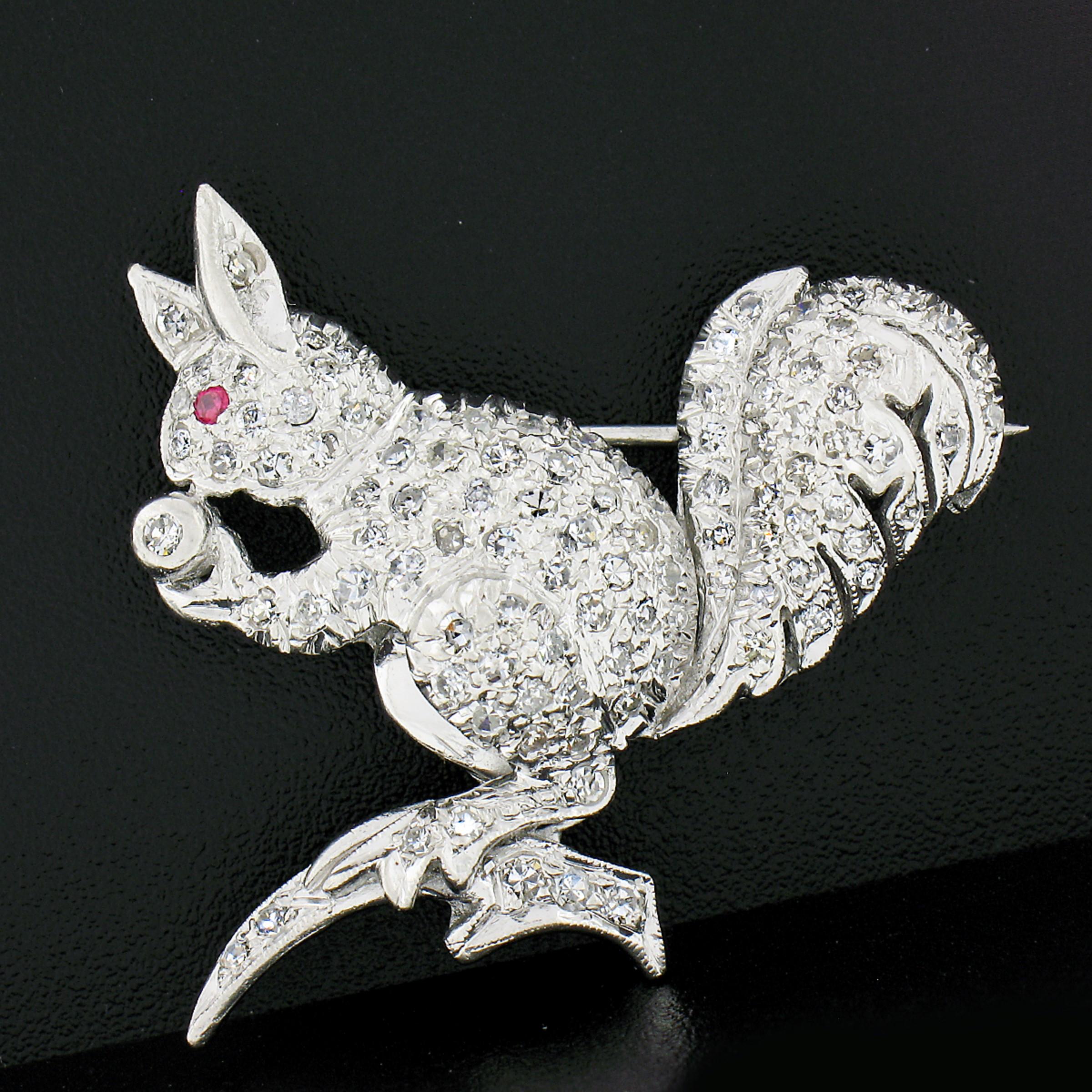 This outstanding antique pin/brooch was crafted in solid platinum during the art deco period and features a well-made squirrel design that is drenched with fine diamonds with a ruby neatly set at the eye. These amazing stones show remarkable