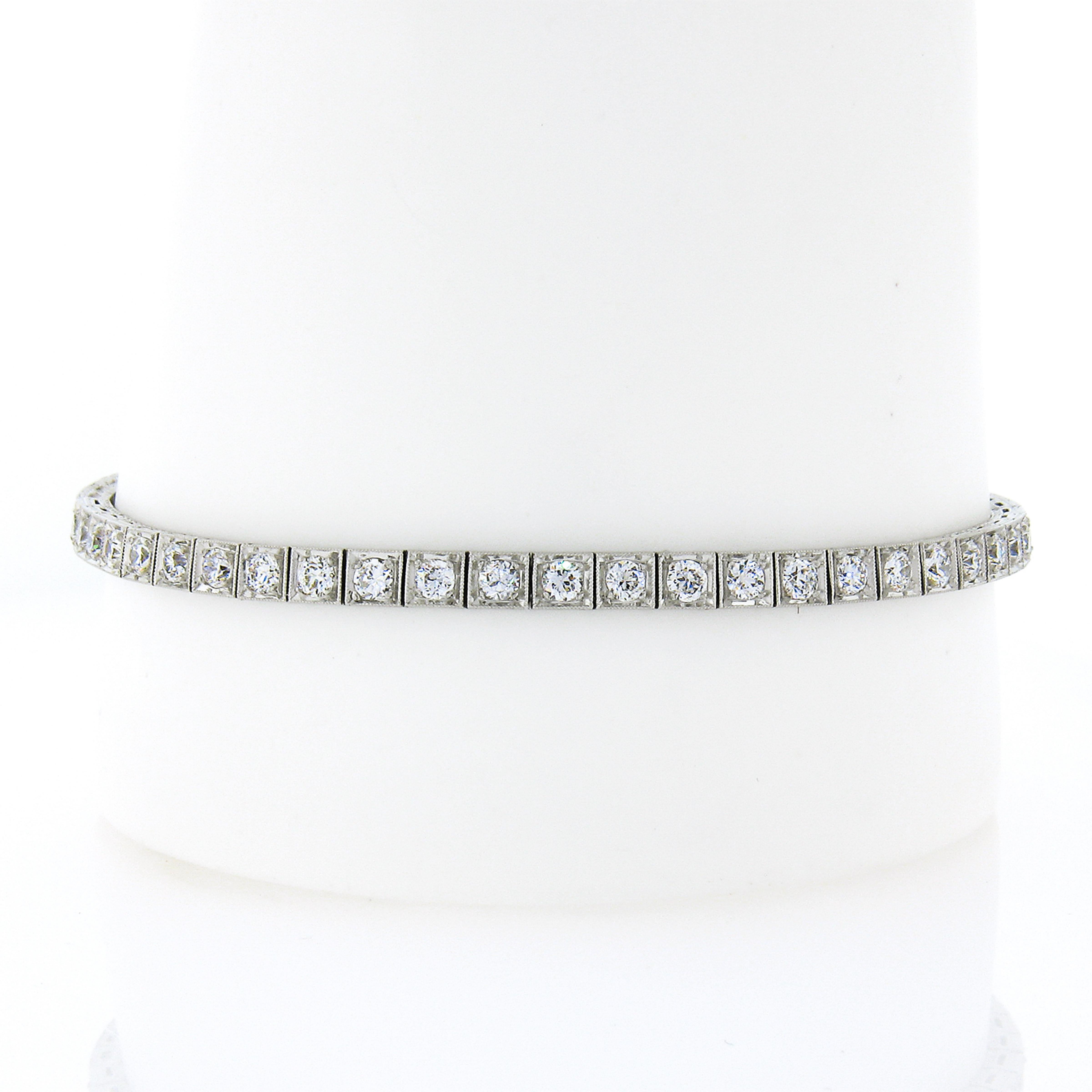 Here we have a gorgeous classic antique art deco diamond tennis bracelet crafted in solid platinum and features 52 old European and transitional cut diamonds neatly set in square prong settings and decorated with Milgrain etching technique