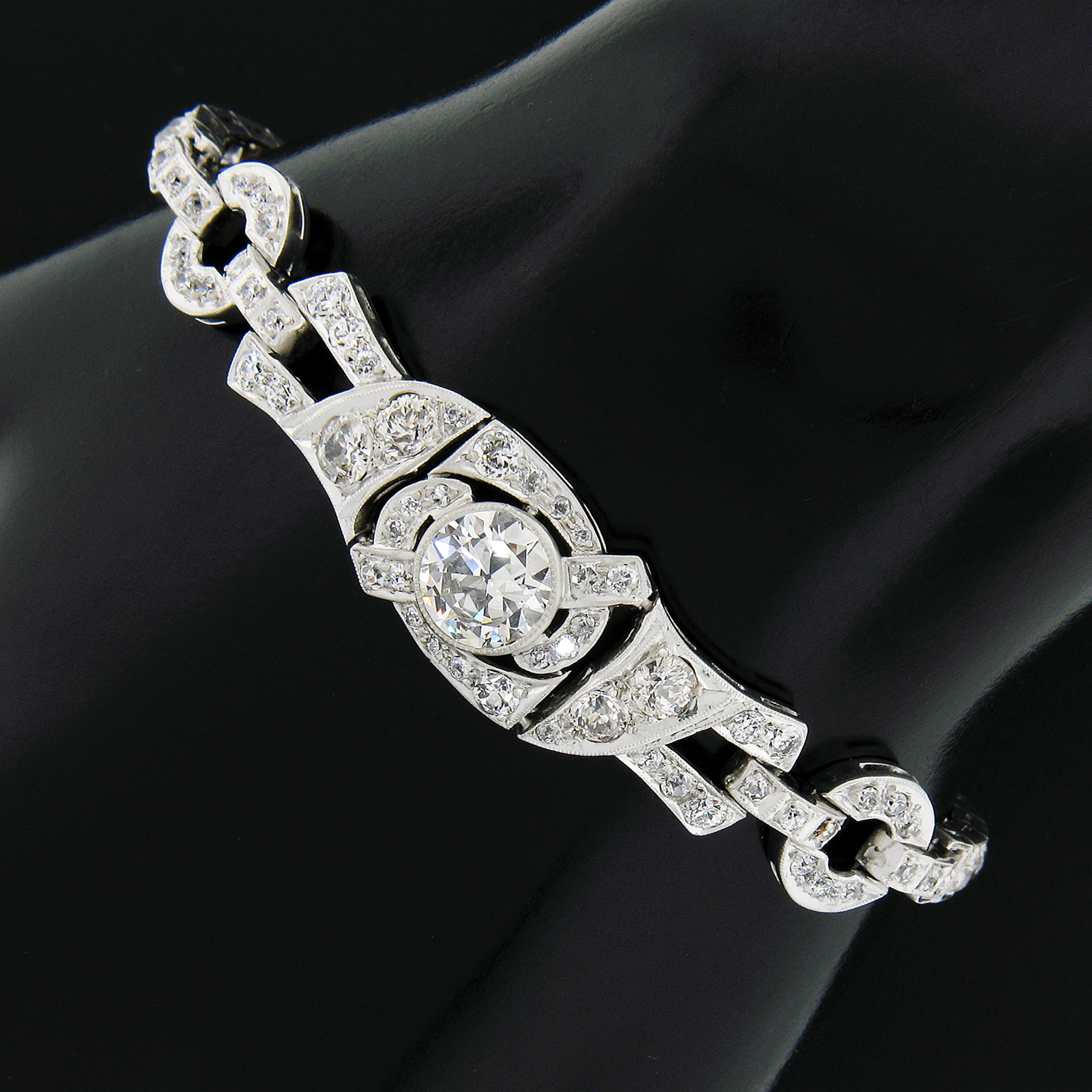 Here we have an absolutely stunning diamond drenched bracelet, which was crafted from solid .900 platinum during the art deco period, featuring a large, GIA certified, old European cut diamond neatly bezel set at at its center. This large stone is