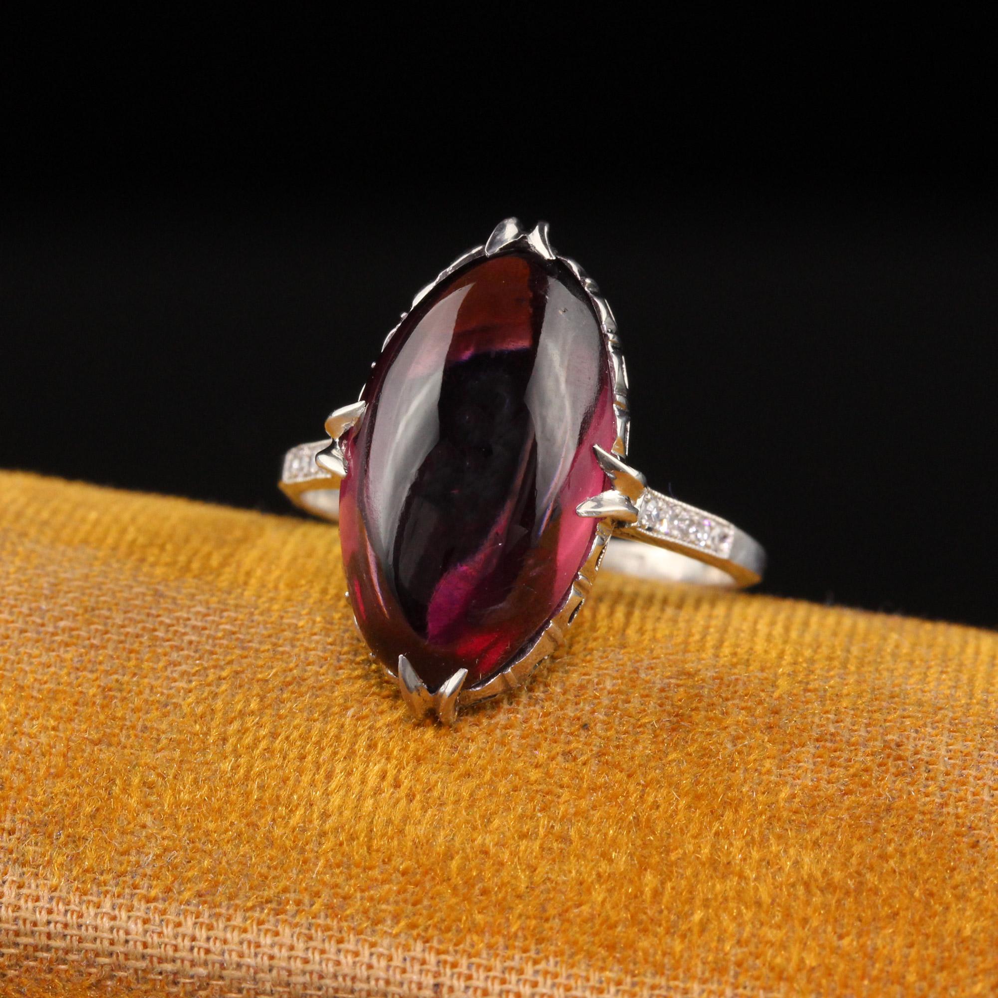Beautiful Antique Art Deco Platinum Cabochon Rhodolite Garnet and Diamond Cocktail Ring. This beautiful cocktail ring is crafted in platinum. The center holds a vibrant cabochon rhodolite garnet and has single cut diamonds going down the shank. The