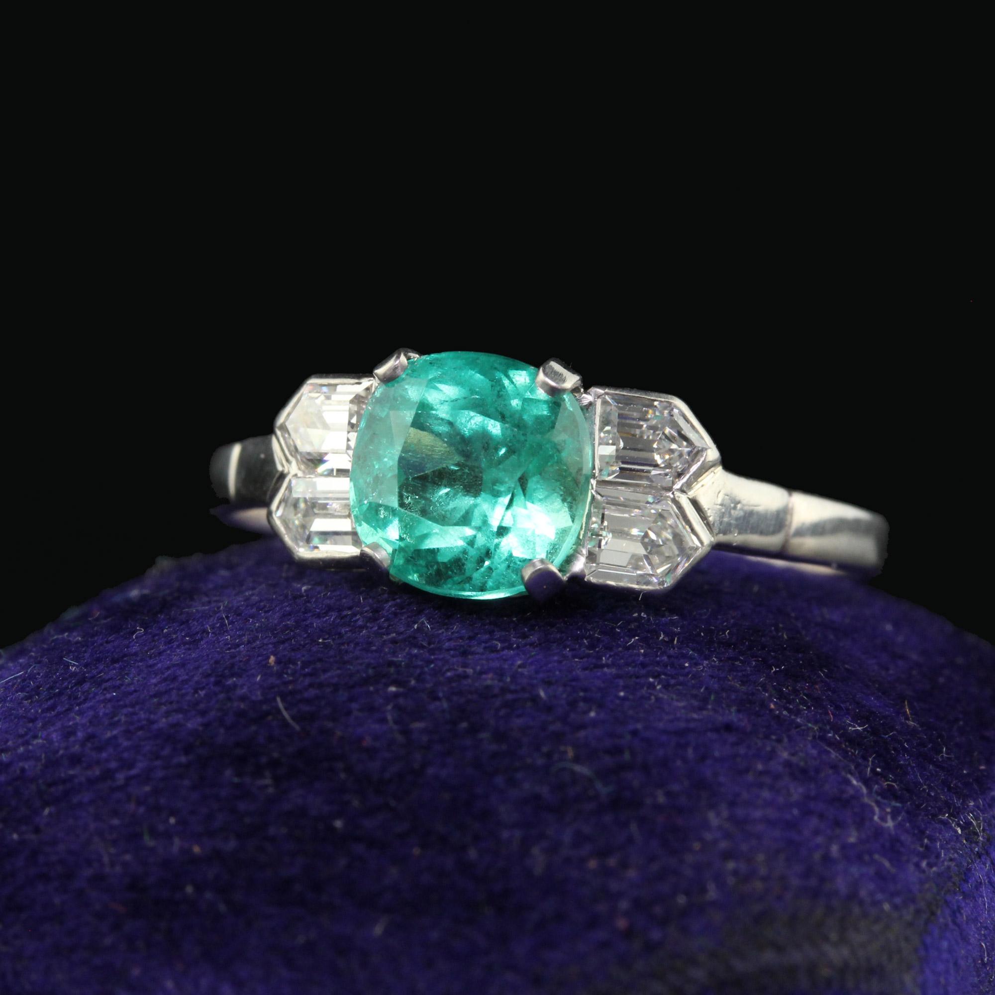 Beautiful Antique Art Deco Platinum Colombian Emerald and Diamond Engagement Ring. This incredible engagement ring is crafted in platinum. The center holds a gorgeous Colombian emerald and has bullet cut diamonds on either side. The ring sits low on
