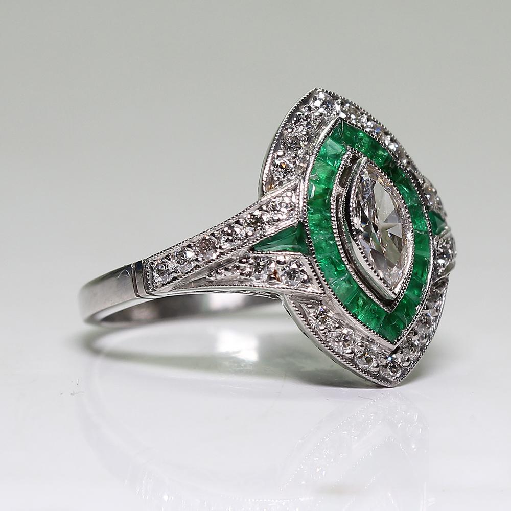 Period: Art Deco (1920-1935)
Composition: Platinum
Stones:
•	1 Old mine marquise cut diamond of H-VS2 quality that weighs 0.40ctw. 
•	28 Old mine cut diamonds of H-VS2 quality that weigh 0.45ctw.
•	22 natural calibrated cut emeralds that weigh