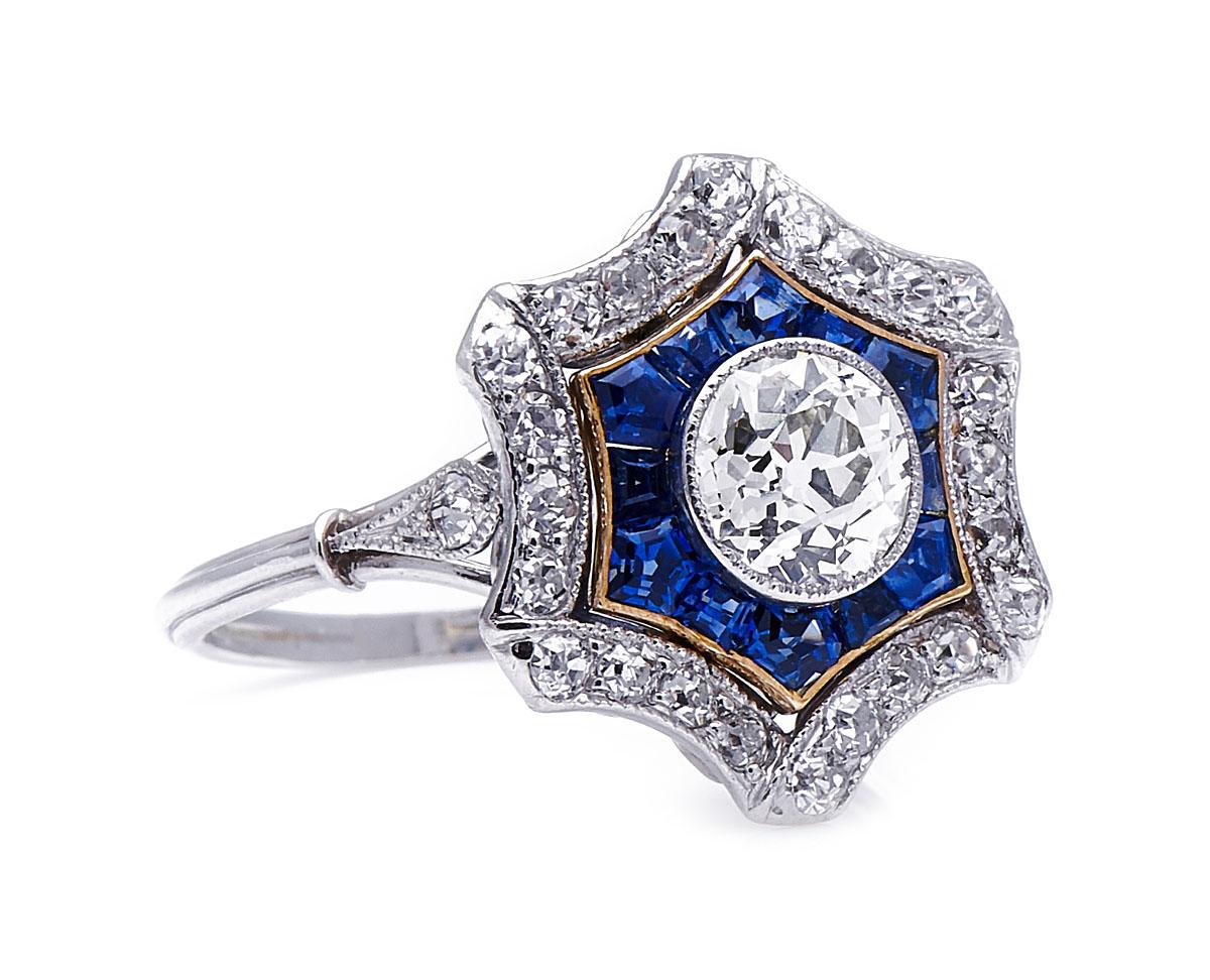 Sapphire and diamond ring, circa 1915. This charming ring, designed as a hexagonal rosette, is deceptively simple. With an outer border designed as a folding ribbon, the openwork centre appears to float within it: a contrasting border of yellow gold