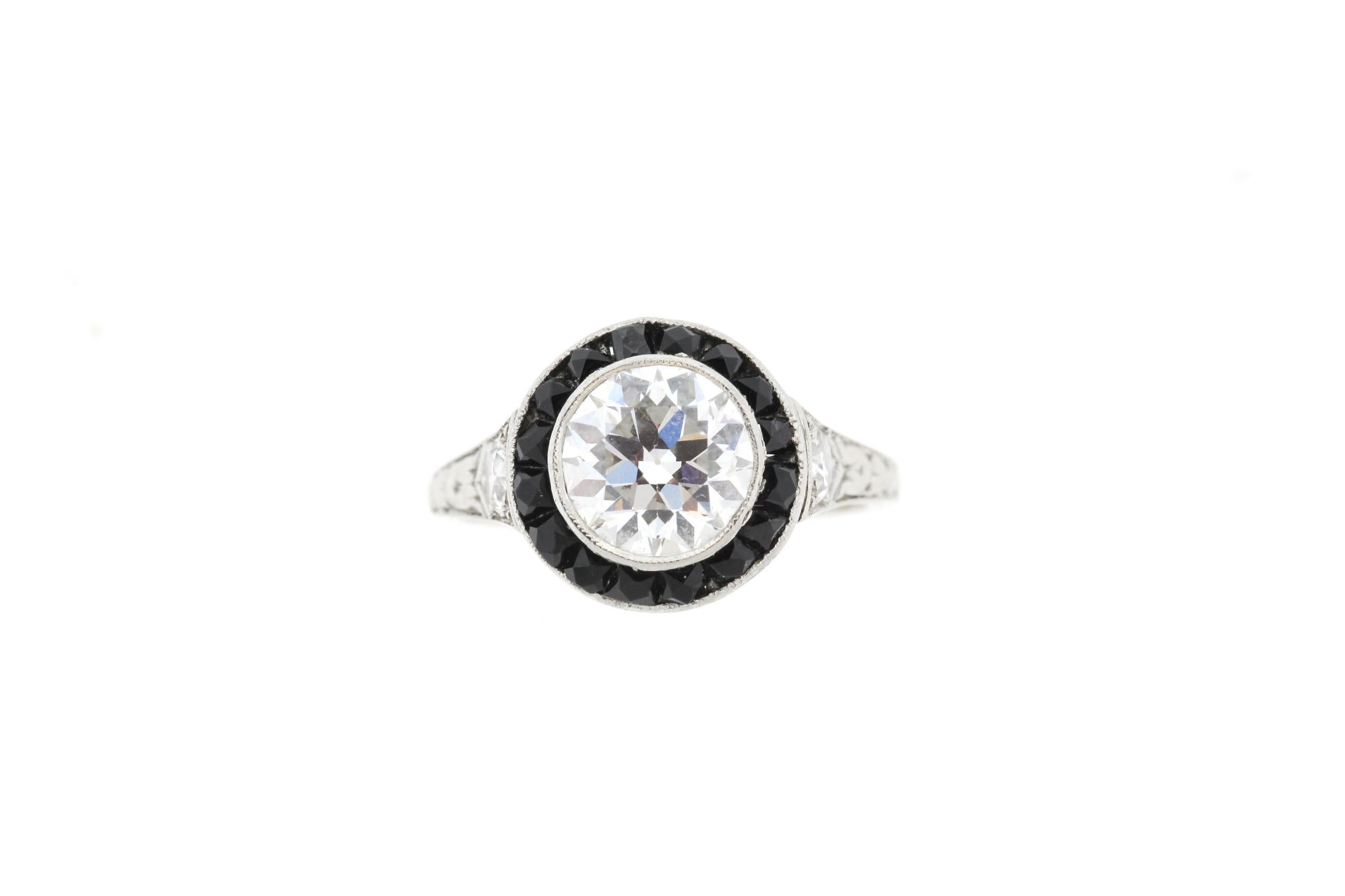 A gorgeous Art Deco example of a onyx and diamond halo ring, circa 1920. The ring centers on an Old European Cut diamond weighing approximately 1.15 carats (by formula). The diamond in our estimation is a G to H color and VS 1 or 2 clarity. It is a