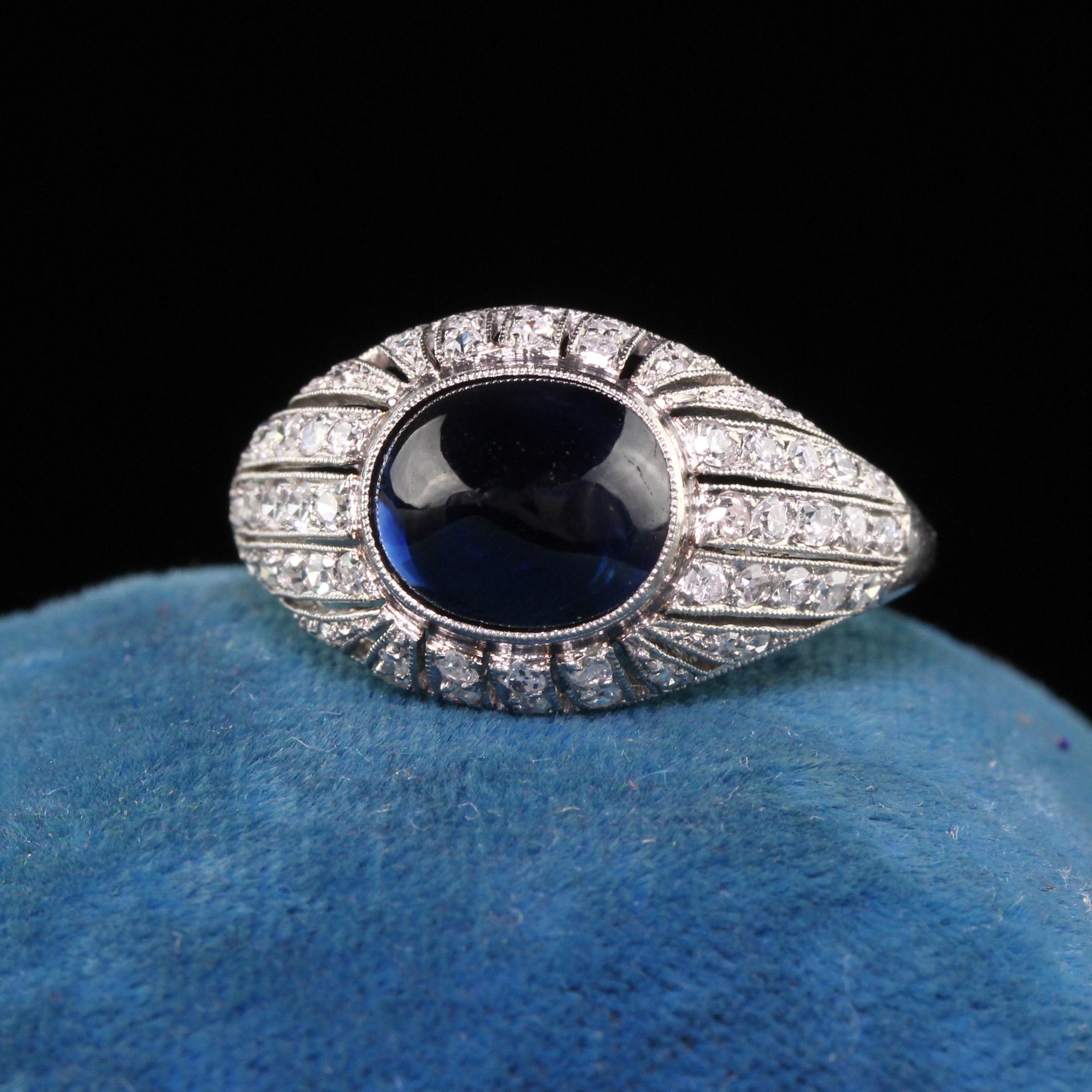 Beautiful Antique Art Deco Platinum French Sugarloaf Sapphire Diamond Engagement Ring. This incredible engagement ring is crafted in platinum. The center holds a natural sugarloaf sapphire in a French mounting. There are chunky single cut diamonds