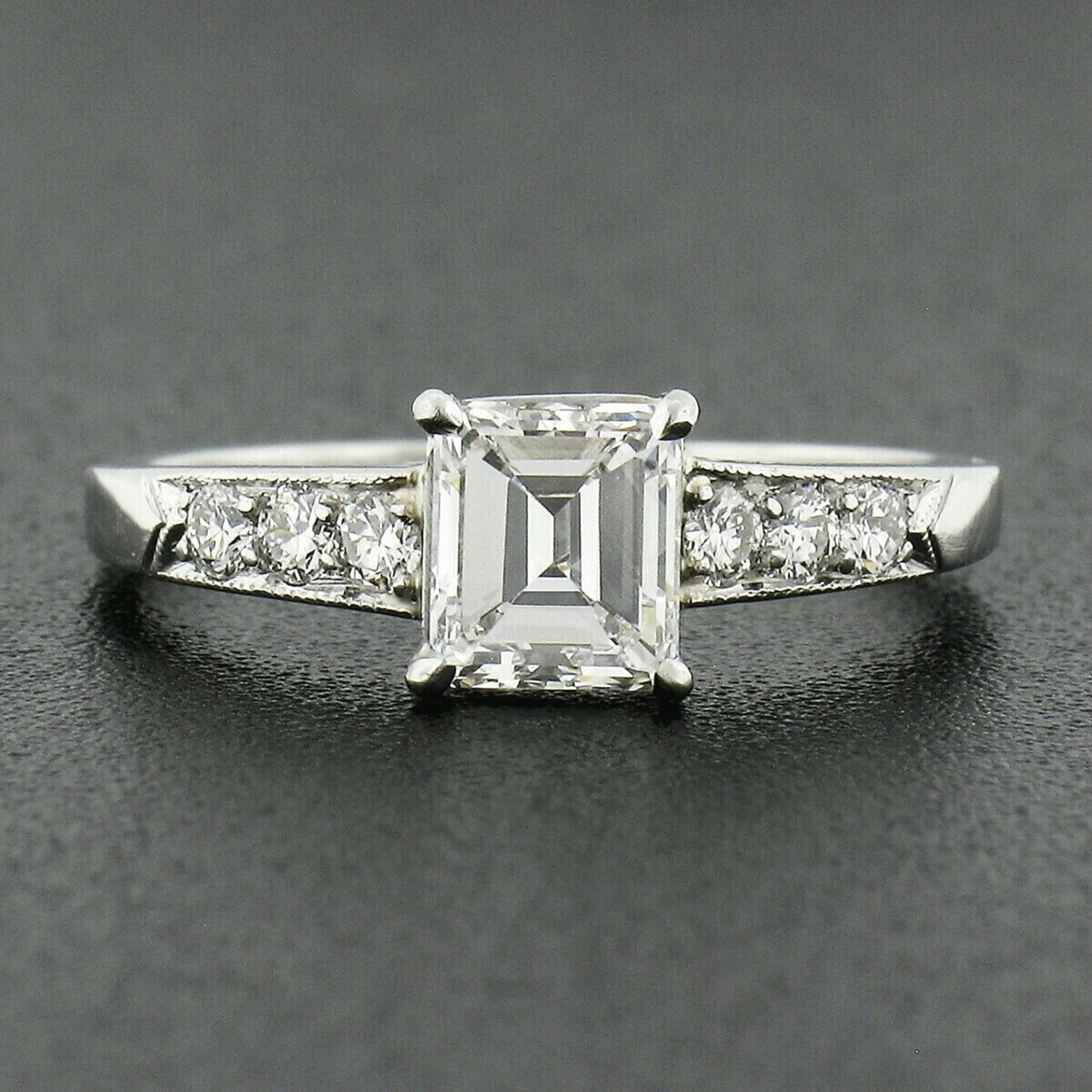 This absolutely gorgeous antique engagement ring was crafted during the art deco period from solid platinum and features a TOP QUALITY emerald cut diamond solitaire neatly prong set at its center. This stunning old stone is GIA certified as weighing