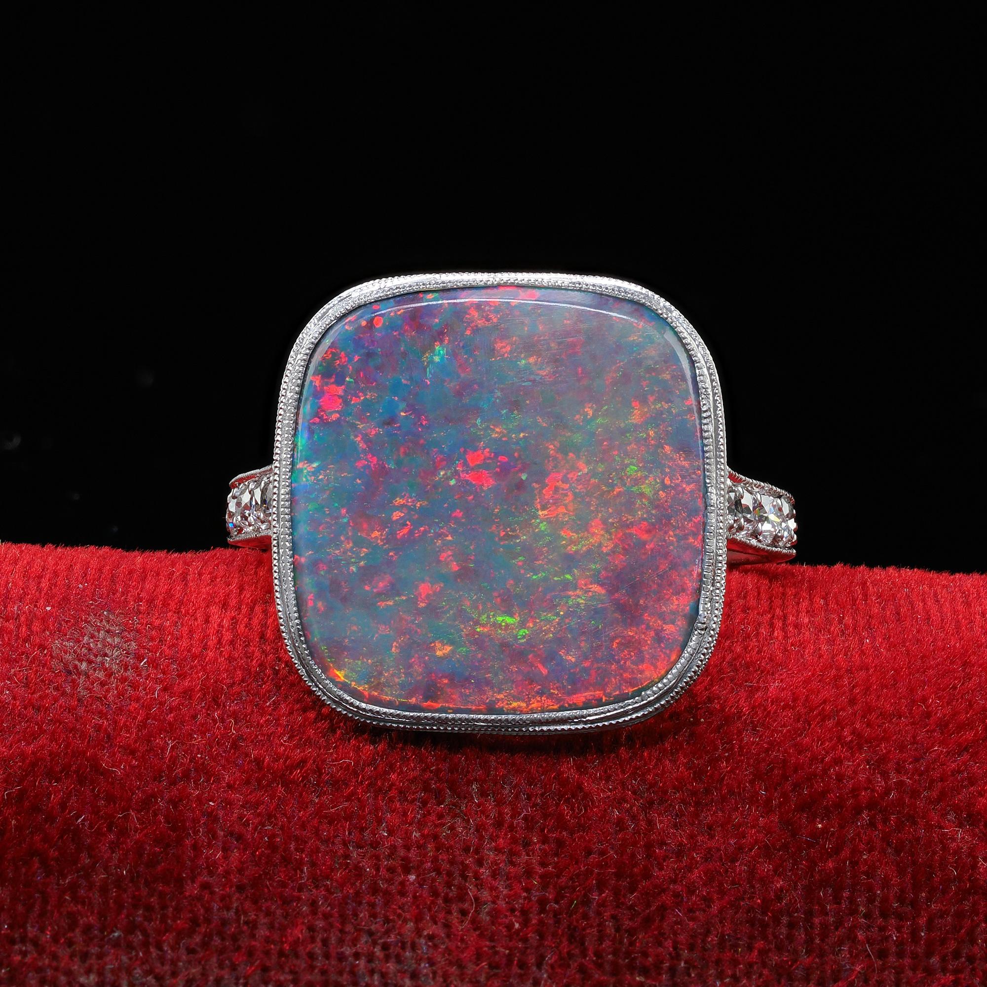 Beautiful Antique Art Deco Platinum J. E. Caldwell Natural Black Opal and Diamond Ring. This unbelievable Art Deco J. E. Caldwell black opal ring is crafted in platinum. This ring features a natural solid black opal that has a vibrant play of colors