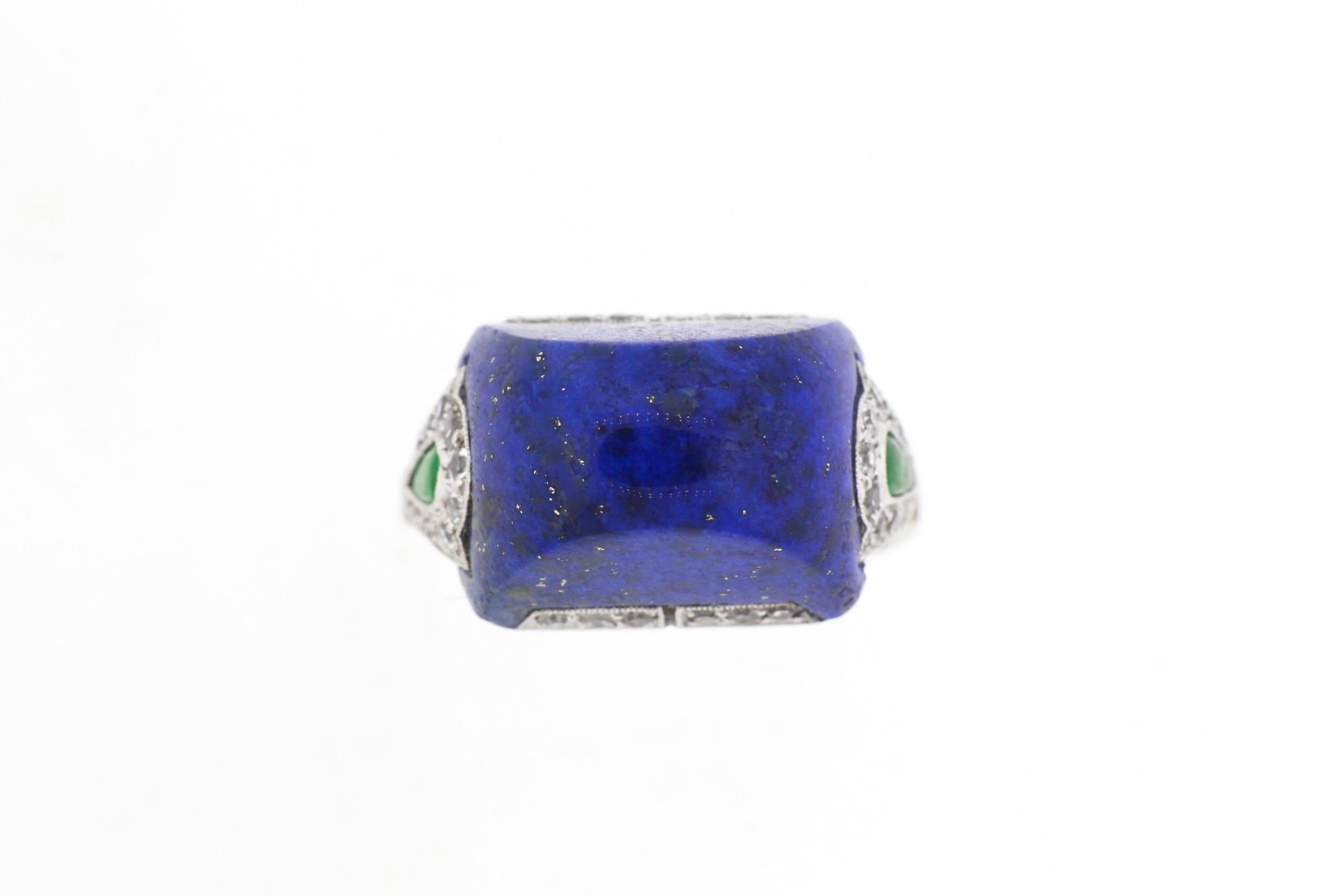 An Art Deco lapis and diamond ring with jade accents, circa 1920. Centering upon a sugar loaf cut domed lapis, the shoulders are set with rosecut diamonds and accented by a pear shape jade. The colors and design are classic Art Deco elements. The
