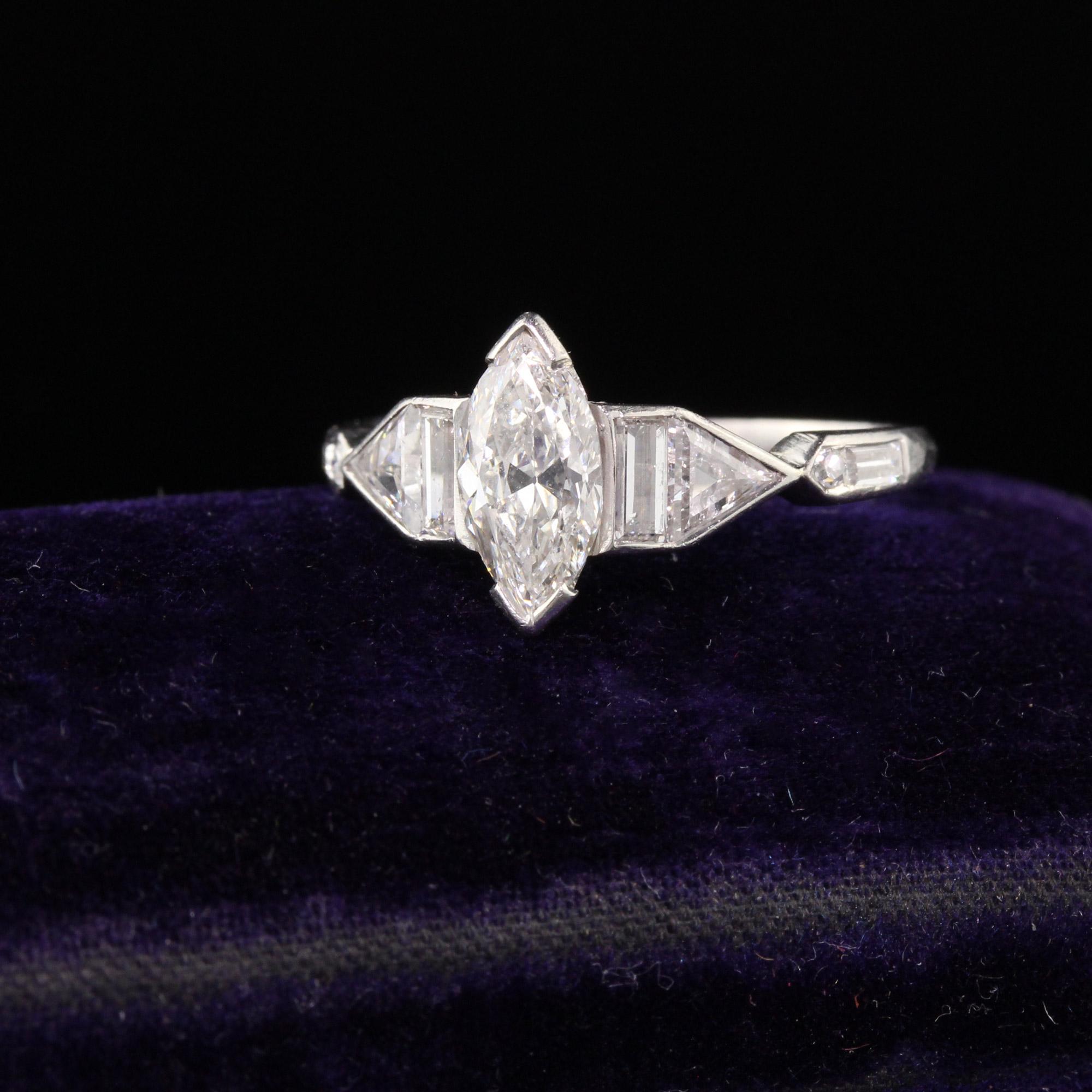 Magnificent Art Deco engagement ring in platinum featuring an old cut marquise in the center surrounded by a vertically set baguette, trillion cut, single cut, and horizontally set baguette on either side. Very unique and absolutely breathtaking. In