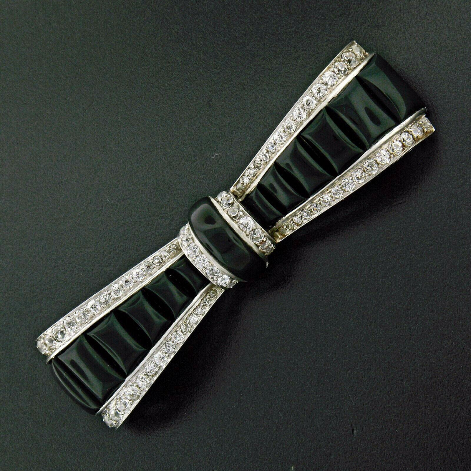 Here we have a truly unique antique pin brooch was crafted from solid .900 platinum during the art deco period. This long pin features a very lovely bow design structured from cabochon calibre cut black onyx stones throughout and further framed with