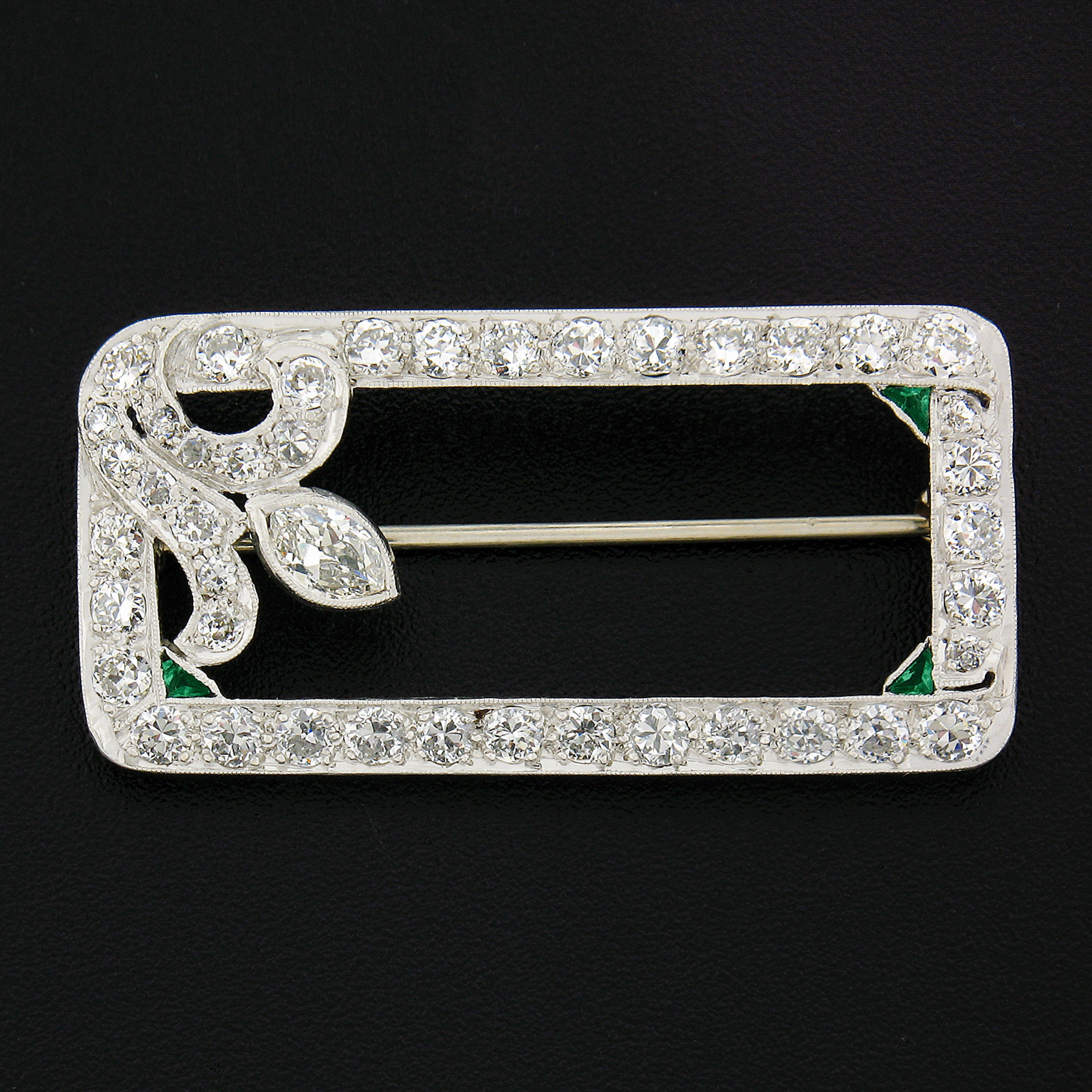 Here we have a stunning art deco diamond brooch crafted in solid platinum.  3 corners of the inside rectangle are adorned with 3 triangular cut emeralds with beautiful green color that set in bezel Milgrain settings. The brooch  is completely