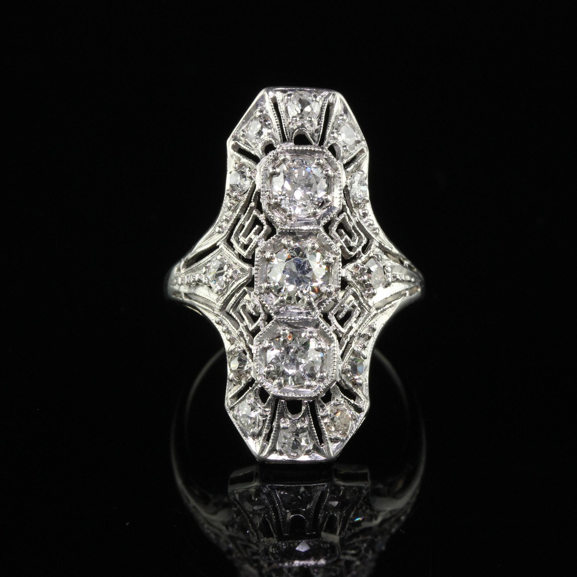 Beautiful Antique Art Deco Platinum Old Euro Diamond and Filigree Shield Ring. This incredible shield ring is crafted in platinum. The center of the ring holds a row of old European cut diamonds and is surrounded by old European cut diamonds set in