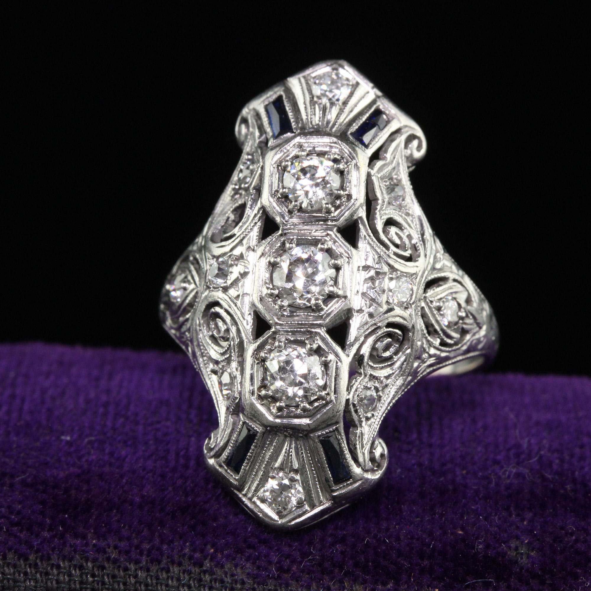 Beautiful Antique Art Deco Platinum Old Euro Diamond and Sapphire Shield Ring. This beautiful shield ring is crafted in platinum. There are old european cut diamonds and French cut sapphires set in a gorgeous filigree mounting. The ring is in good