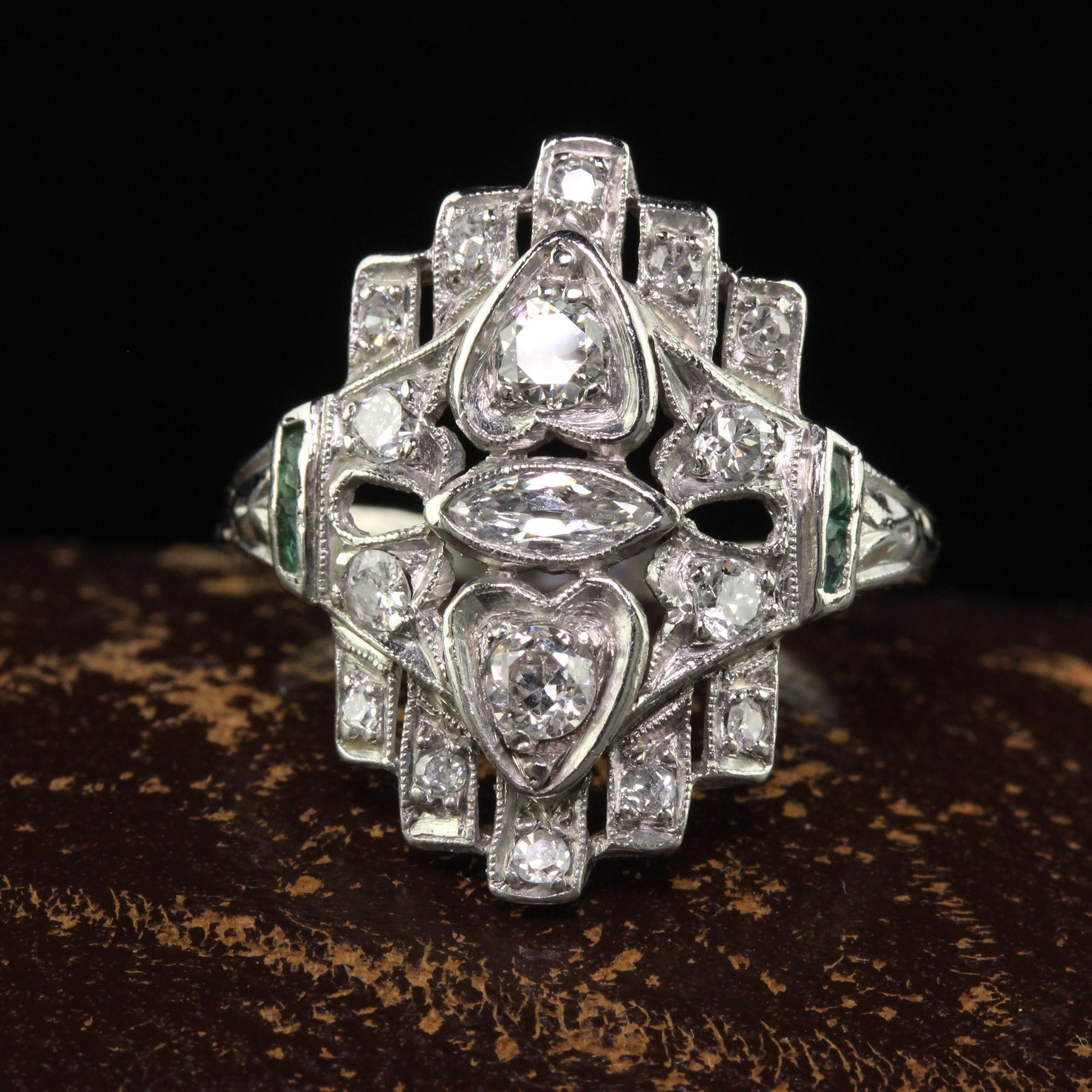 Beautiful Antique Art Deco Platinum Old Euro Marquise Diamond and Emerald Shield Ring. This gorgeous antique shield ring is crafted in platinum. The ring has old cut diamonds and an old cut marquise that is set east to west in the center with