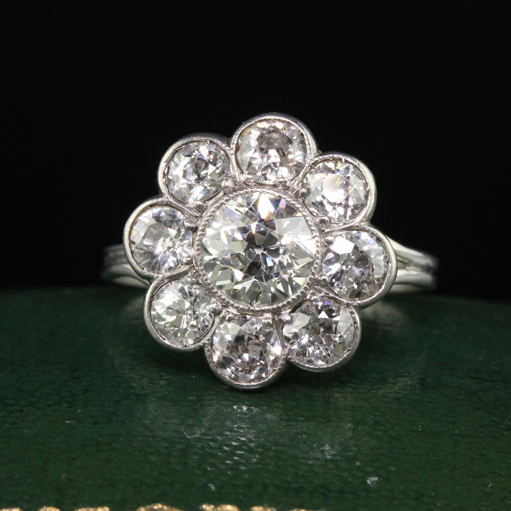 Beautiful Antique Art Deco Platinum Old European Cut Diamond Cluster Engagement Ring. This incredible engagement ring is crafted in platinum. The center is an old European cut diamond that is set in a gorgeous Art Deco mounting that has large old