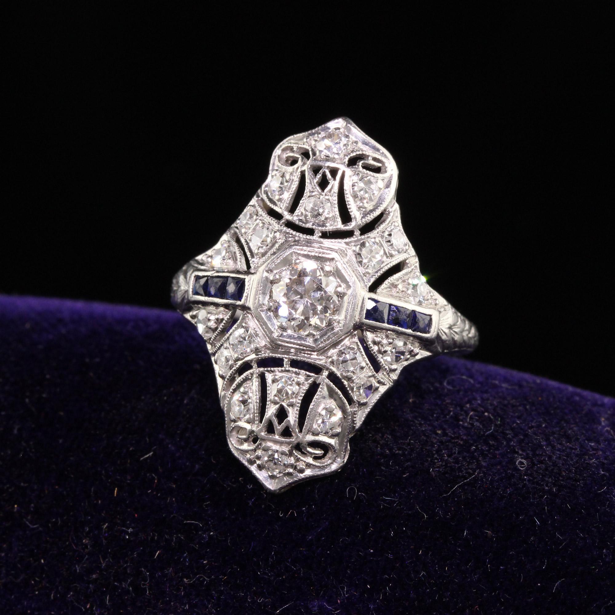 Beautiful Antique Art Deco Platinum Old European Cut Diamond Sapphire Shield Ring. This beautiful ring is crafted in platinum. The ring has old european cut diamonds set on the top with natural sapphires on both sides. The ring is in great condition