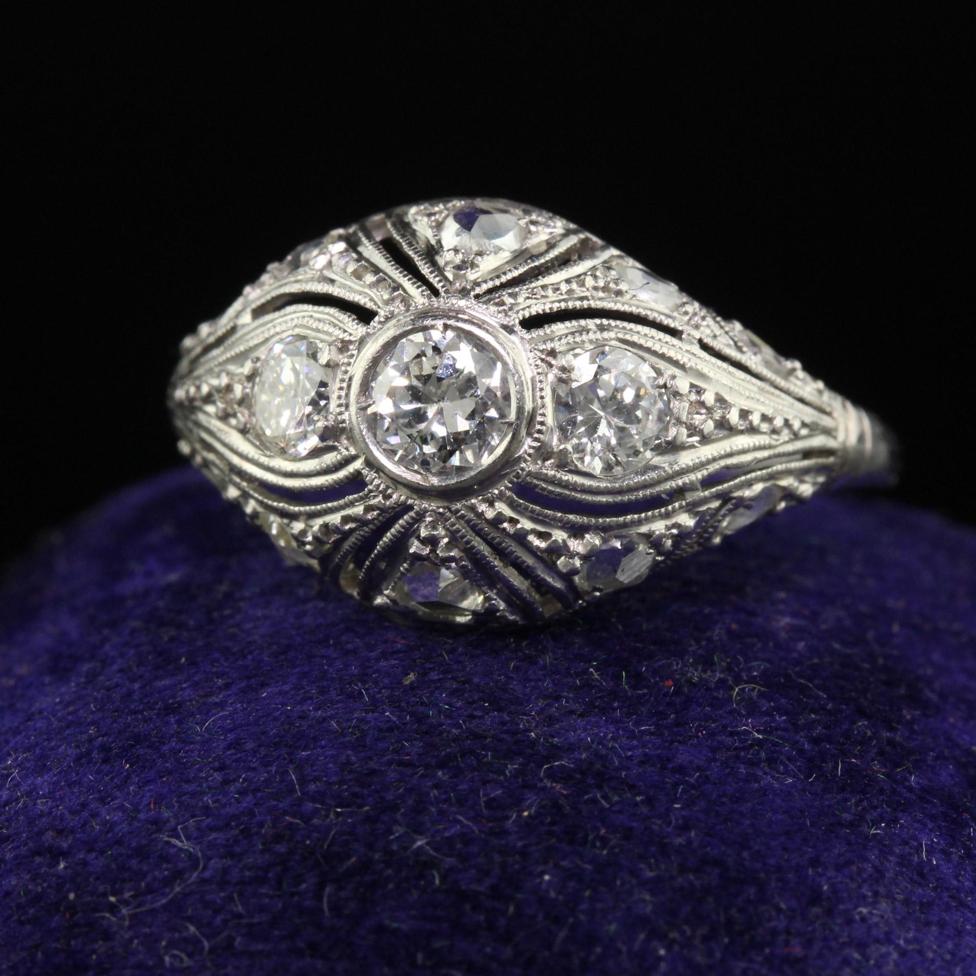 Beautiful Antique Art Deco Platinum Old European Diamond Filigree Engagement Ring. This beautiful engagement ring is crafted in platinum. The center holds three old European cut diamonds on the top with surrounding rose cut diamonds. The ring is in