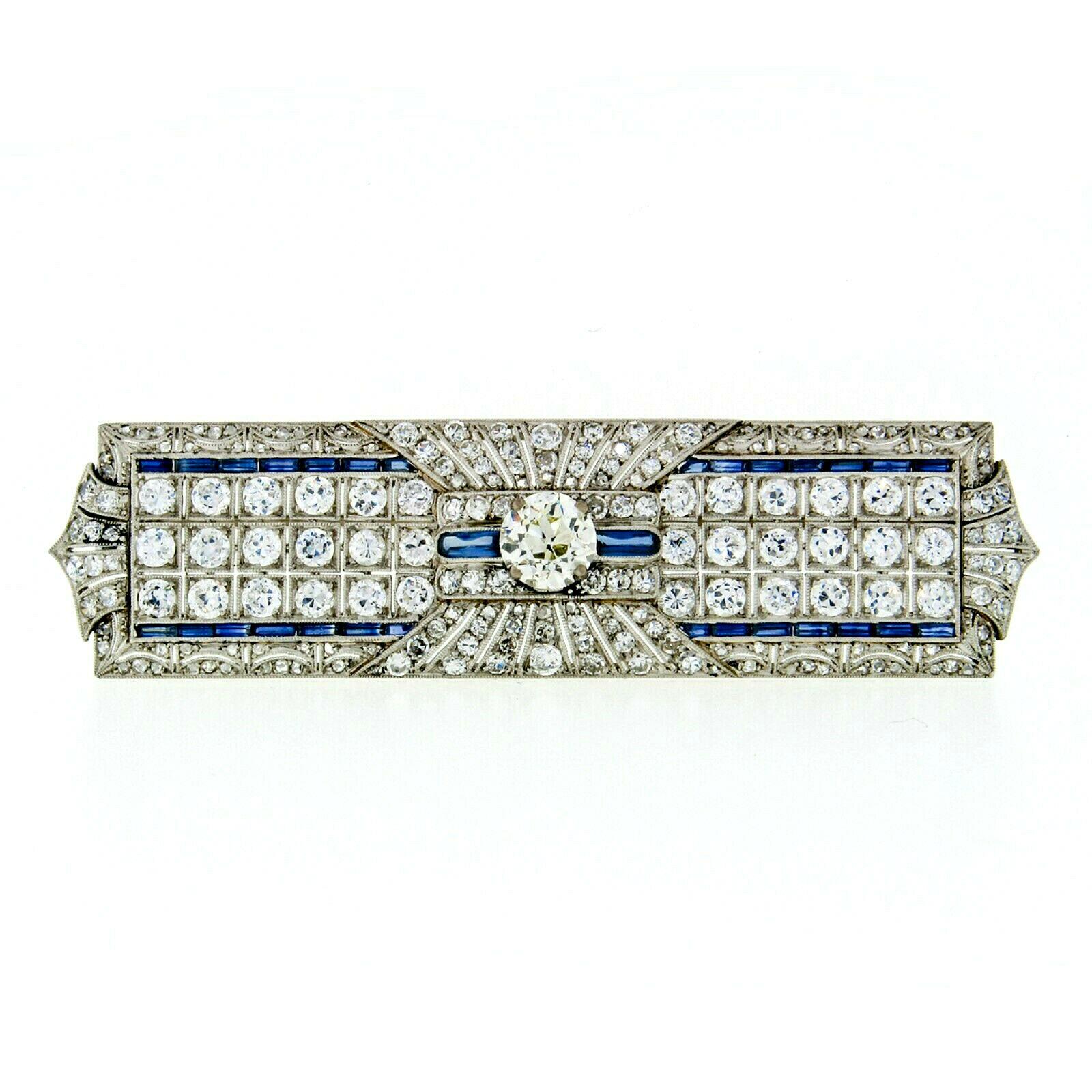 This magnificent antique brooch was crafted from solid .900 platinum during the art deco period. It features a large rectangular shape adorned open filigree work, milgrain etching, and over 7 carats of VERY FINE quality old cut diamonds. The center