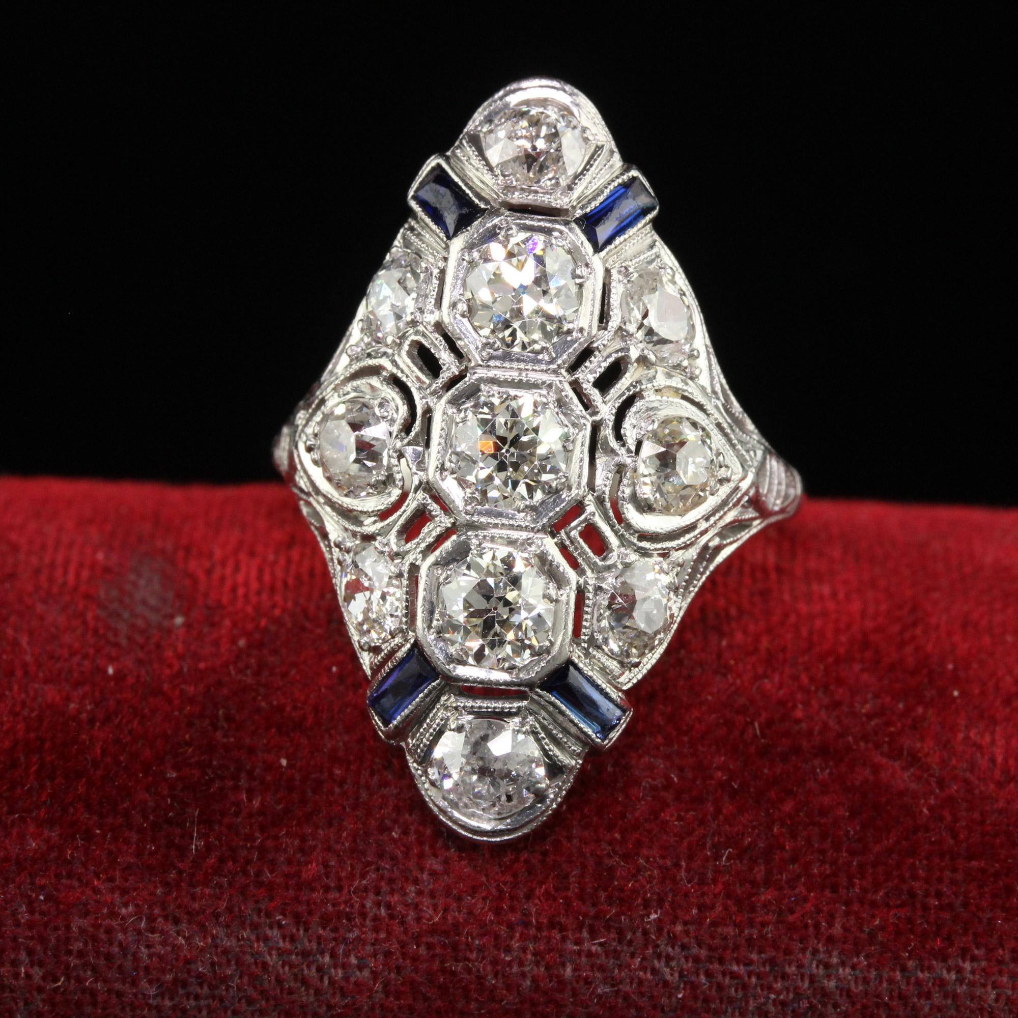 Beautiful Antique Art Deco Platinum Old Mine Diamond and Sapphire Filigree Shield Ring. This gorgeous art deco ring is crafted in platinum. The ring has beautiful chunky old mine cut diamonds set through the ring with French cut sapphire accents.