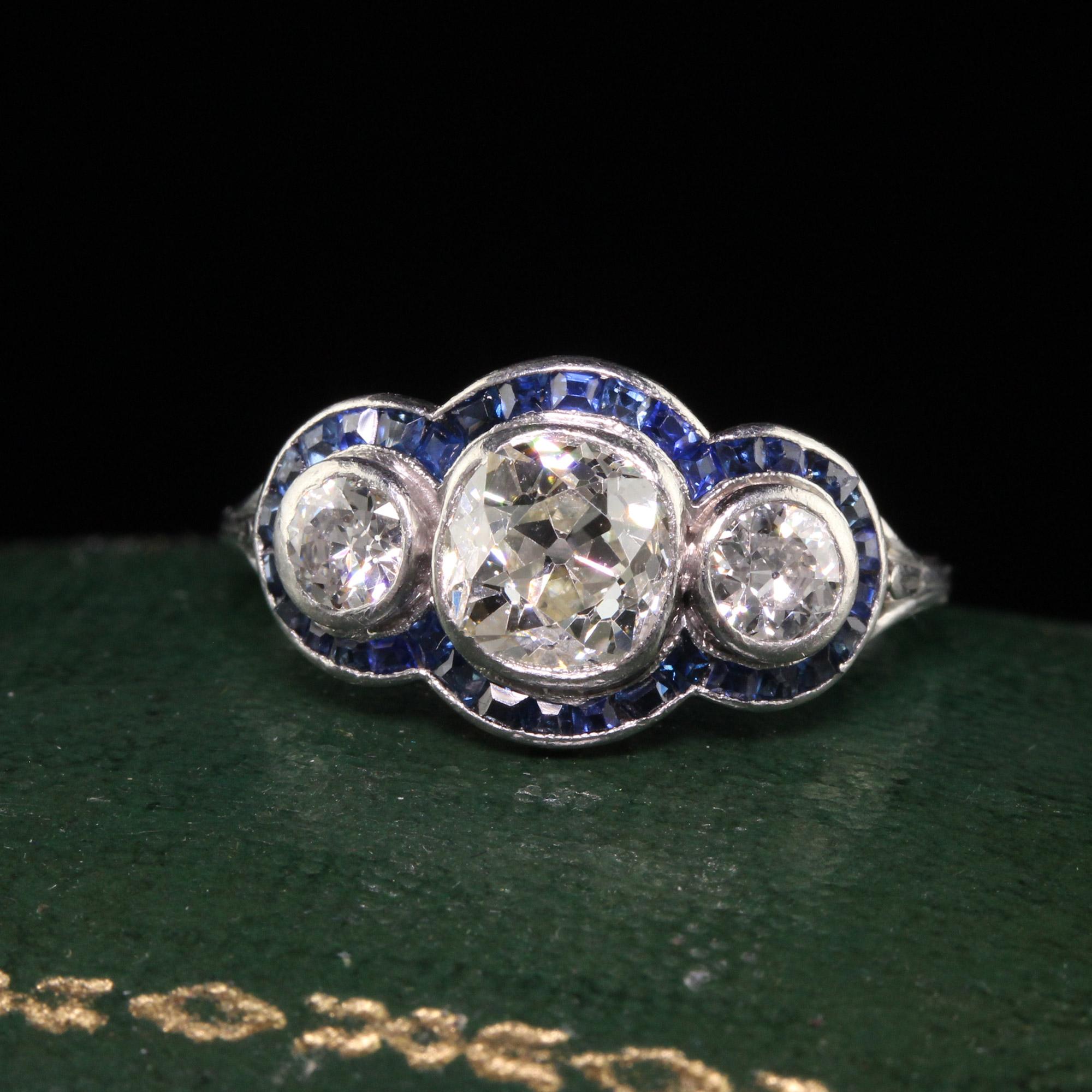 Beautiful Antique Art Deco Platinum Old Mine Diamond and Sapphire Three Stone Ring. This gorgeous three stone ring is crafted in platinum. The center holds an old mine cut diamonds and has two old european cut diamonds on its sides. There are