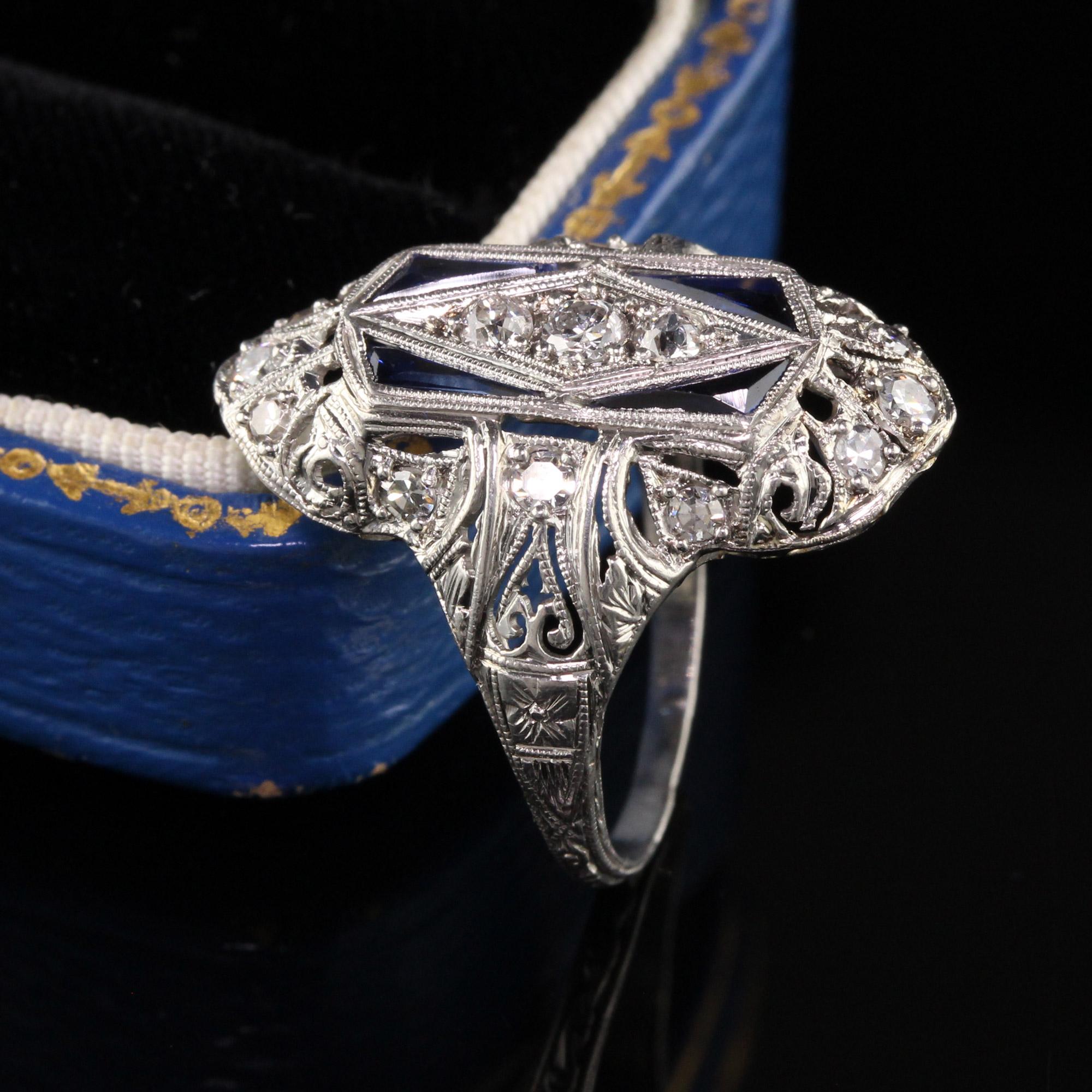 Beautiful Antique Art Deco Platinum Old Mine Diamond Shield Ring. This beautiful ring has old mine cut diamonds and single cut diamonds on the ring with 4 kite shaped synthetic sapphires. The filigree and engravings on the ring are in great